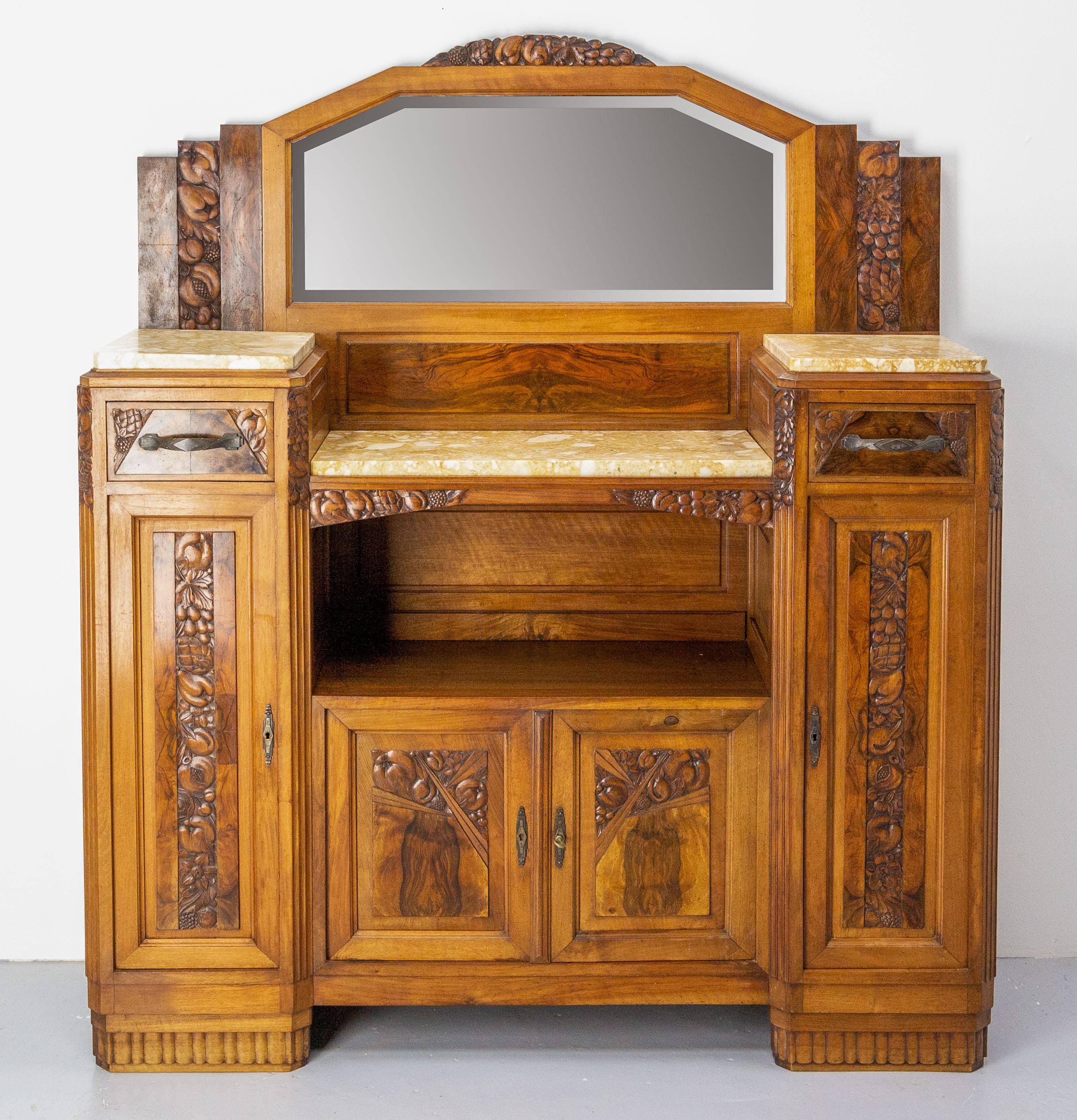 Cabinet Art Deco, French, circa 1930.
Credenza buffet walnut and marble with bas-reliefs on the theme of fruits.
Four doors and two drawers.
The buffet has been made in three parts. 
The tops are recovered of yellow marble.
The mirror is