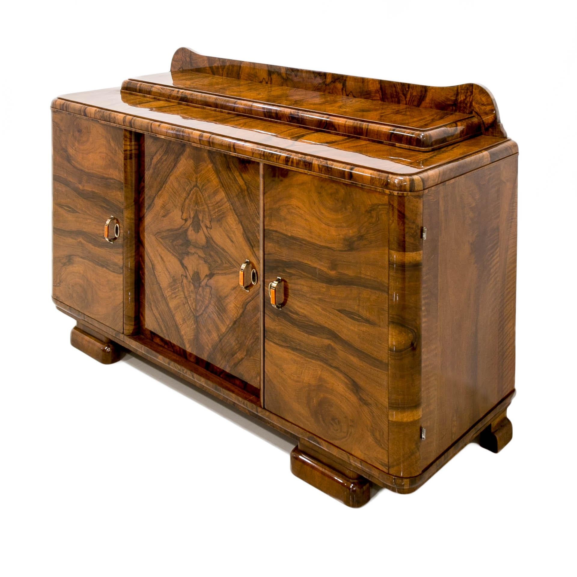 This beautiful credenza was made in Poland in 20th century the piece is made of coniferous and deciduous wood, veneered with European walnut. It features three sections with lots of storage space. Two drawers reside in the section on the left and