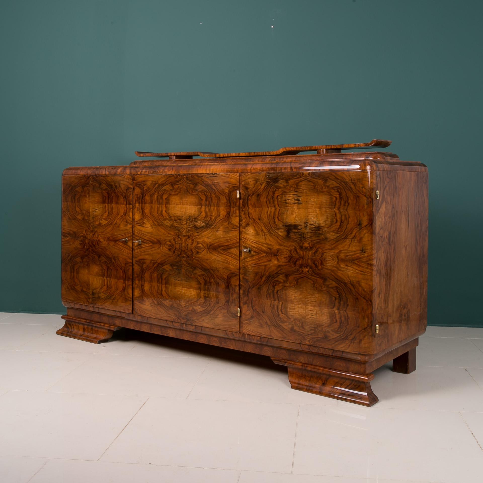 This beautiful credenza was made in Poland in 20th century. The piece is veneered with exceptionally beautiful walnut. It features three sections with lots of storage space. The buffet has undergone thorough, professional renovation and is in