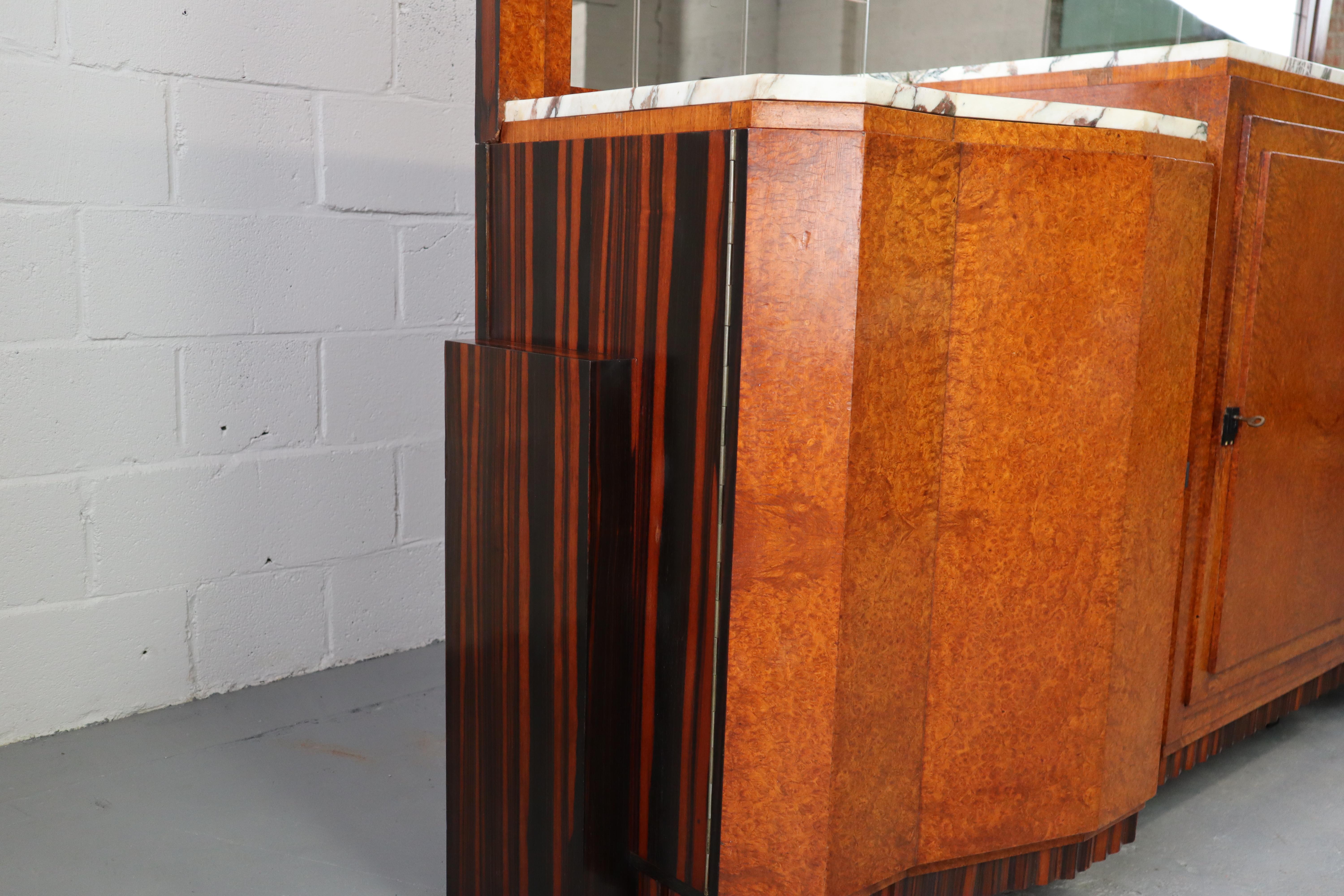 Buffet Art Deco di qualità eccezionale. Rovere massiccio con impiallacciatura in ebano Macassar e impiallacciatura in radica di noce. Il buffet ha un piano con le lastre di marmo originali. Sulla parete di fondo c'è un grande specchio leggermente