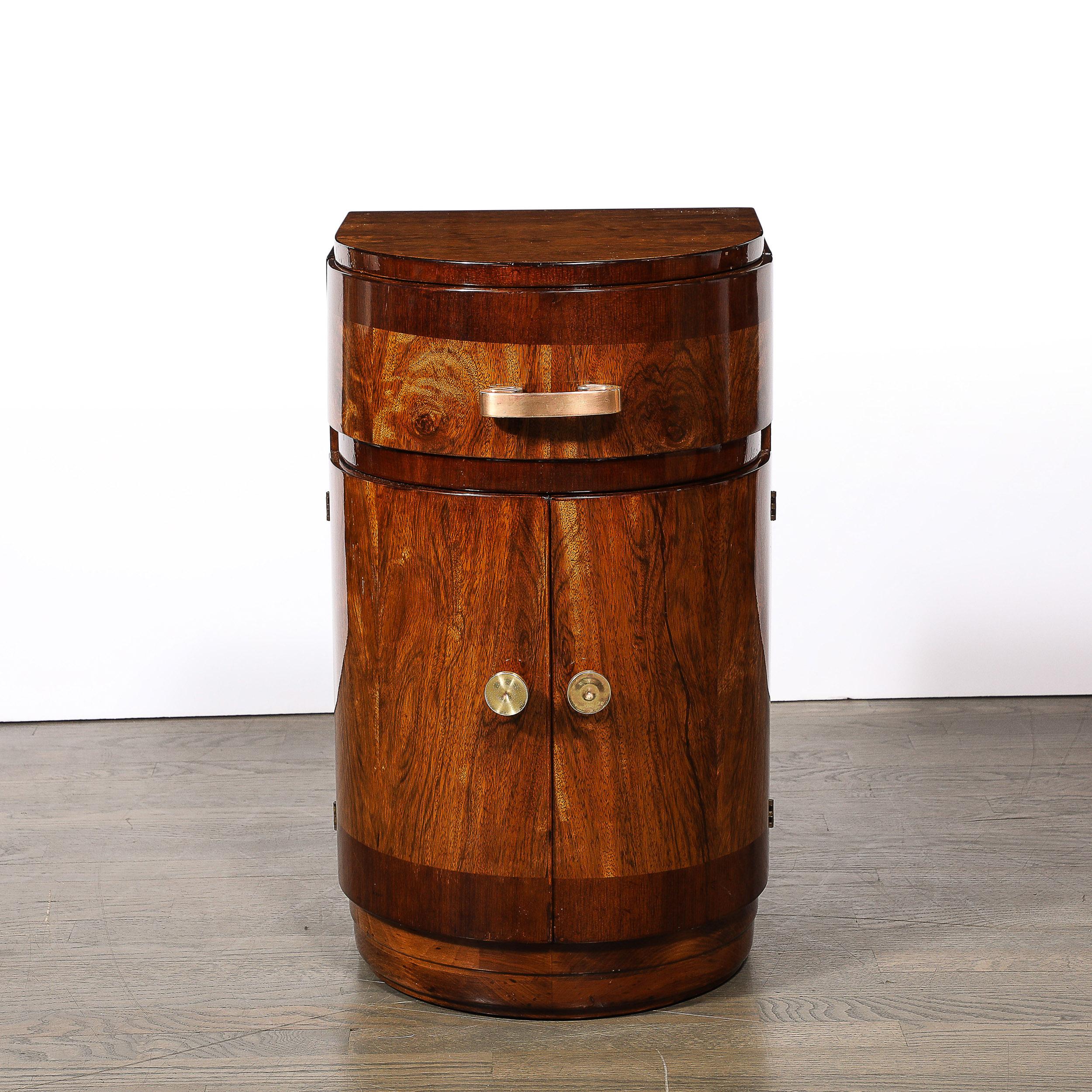 This well proportioned and materially excellent Art Deco Bullet Form End table  in Book-Matched & Burled Walnut W/ Brass Pulls originates from the United States, Circa 1930. Features a sleek and thoughtful composition formed in Book-matched and