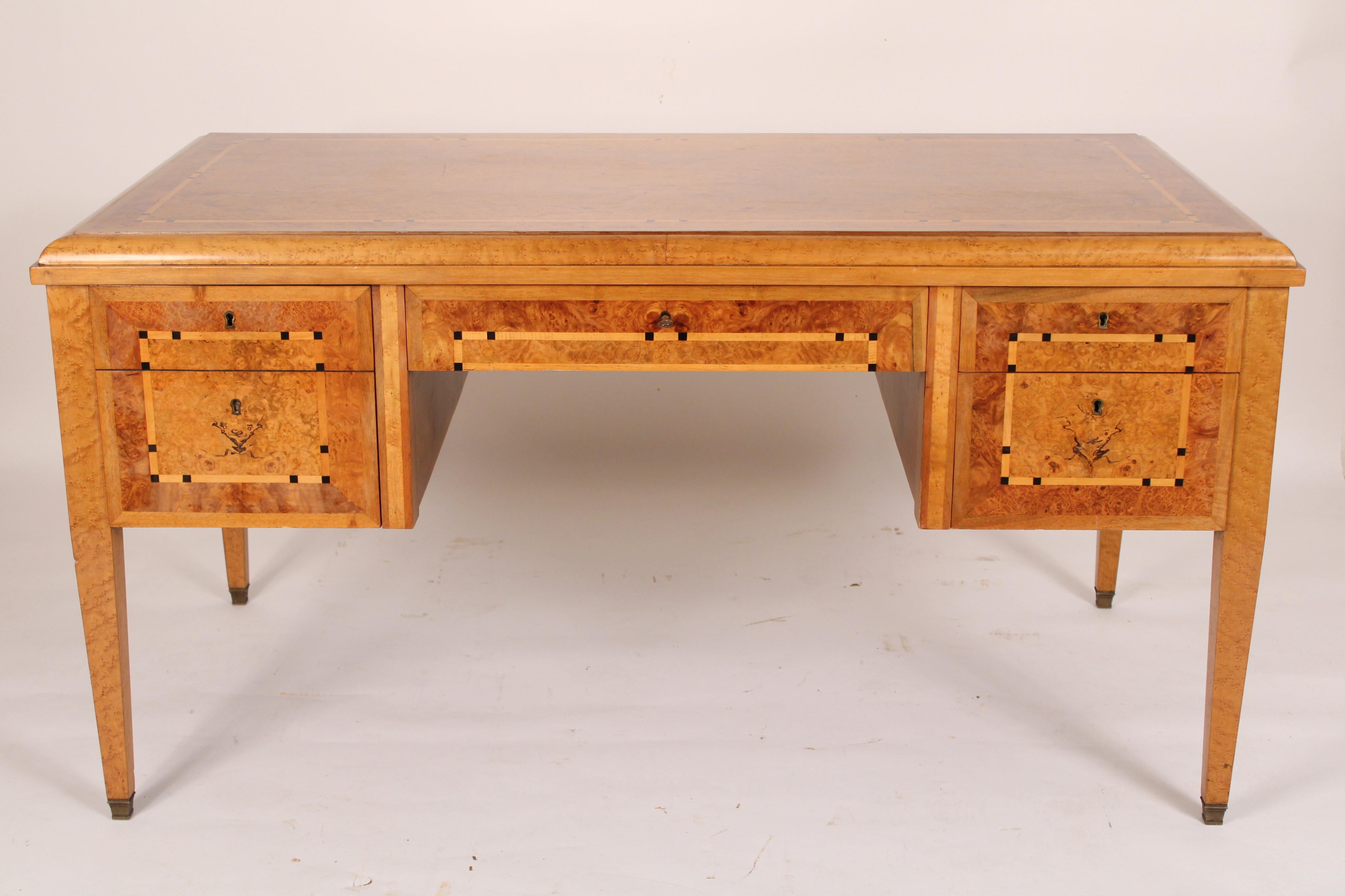 Art Deco burl ash and inlaid writing table, circa 1930's. With an inlaid burl ash top, the front of the desk with a single file drawer on the left side and two drawers on the right side of the knee hole and a center drawer, resting on square tapered