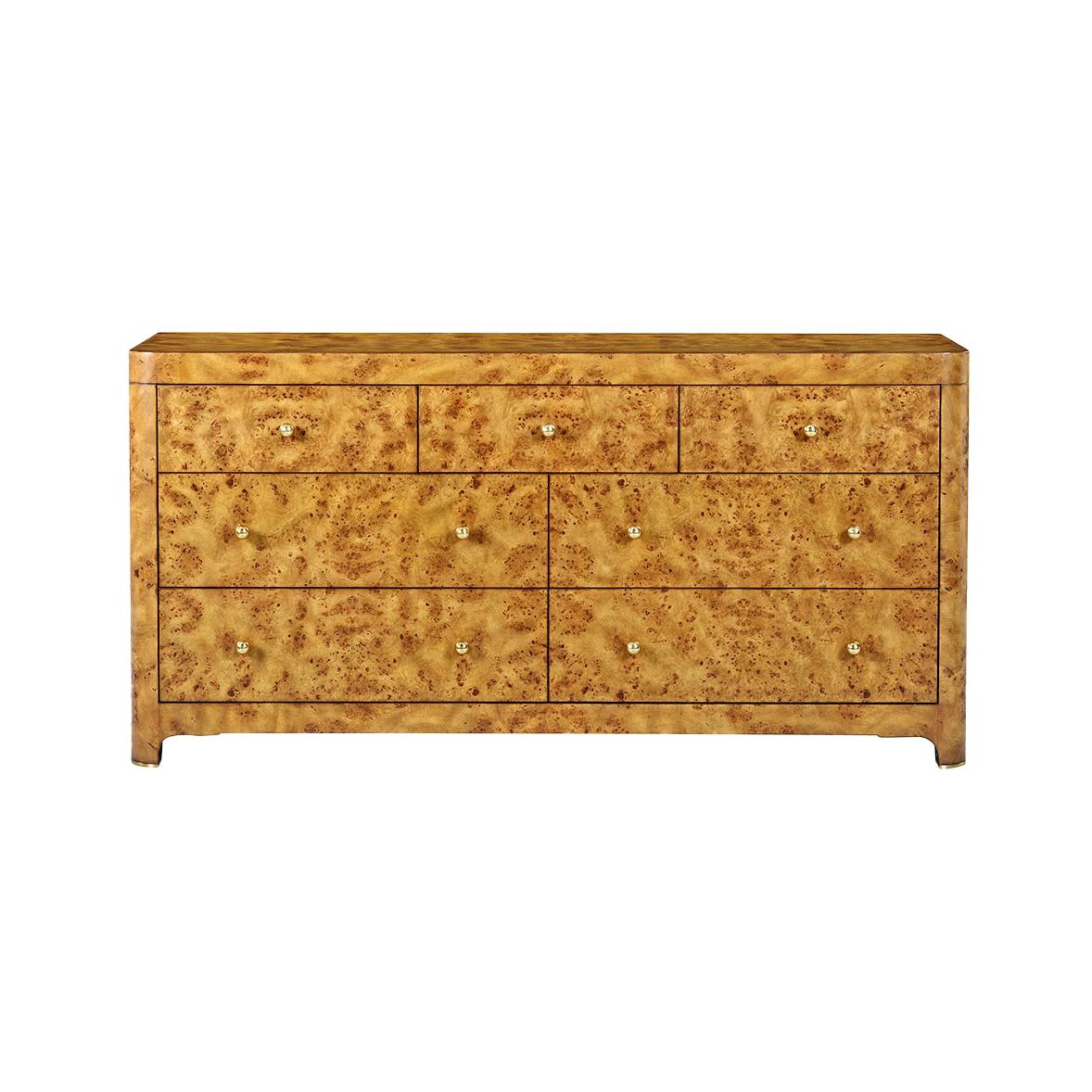 Crafted with a stunning rustic Mappa burl wood veneer, its golden honey tones and intricate wood grain patterns evoke a sense of warmth and sophistication. 

Featuring seven spacious drawers adorned with sleek brass pulls, this piece combines