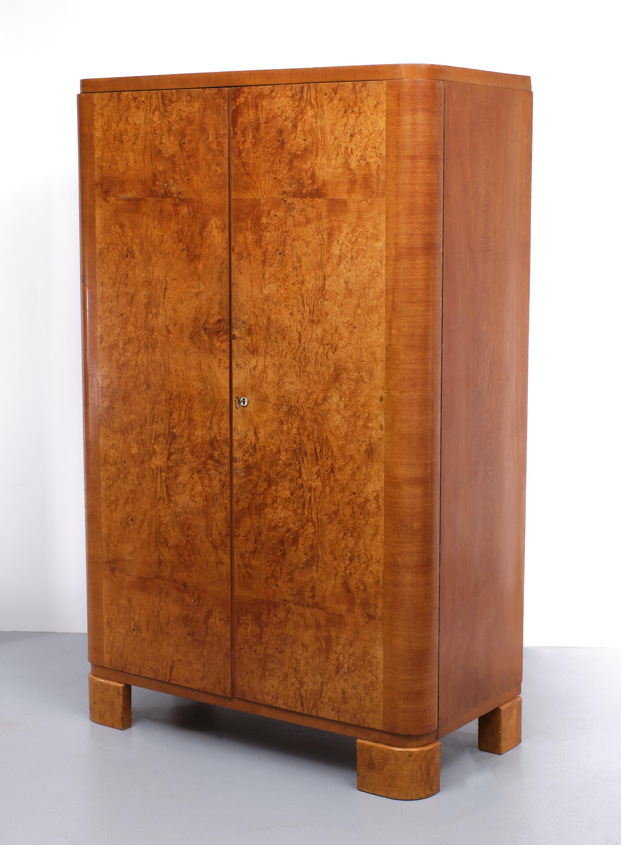 Beautiful impressive Art Deco burl wood wardrobe. Two doors Very nice color. Comes with its original interior 4 solid mahogany shelves and a Bottom drawer with chrome handles.
This is a real period piece. With normal wear and tear. Working lock