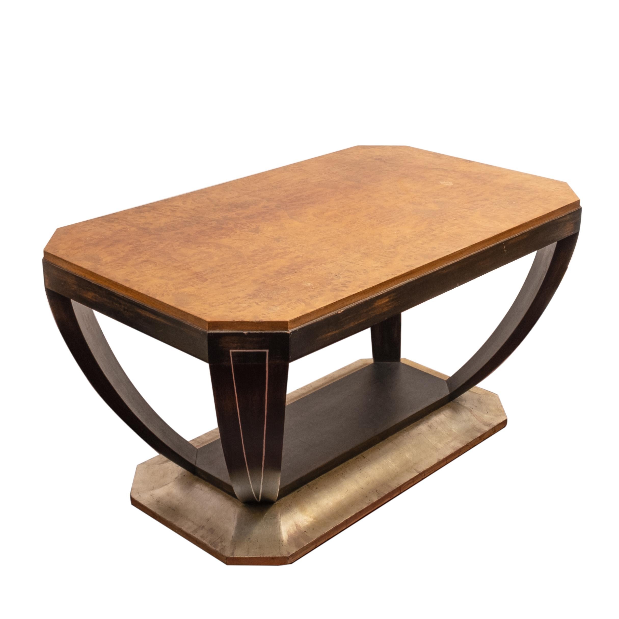 Art deco low table having a burled elm top, black stained legs, raised on a silver leafed base. Unmarked.