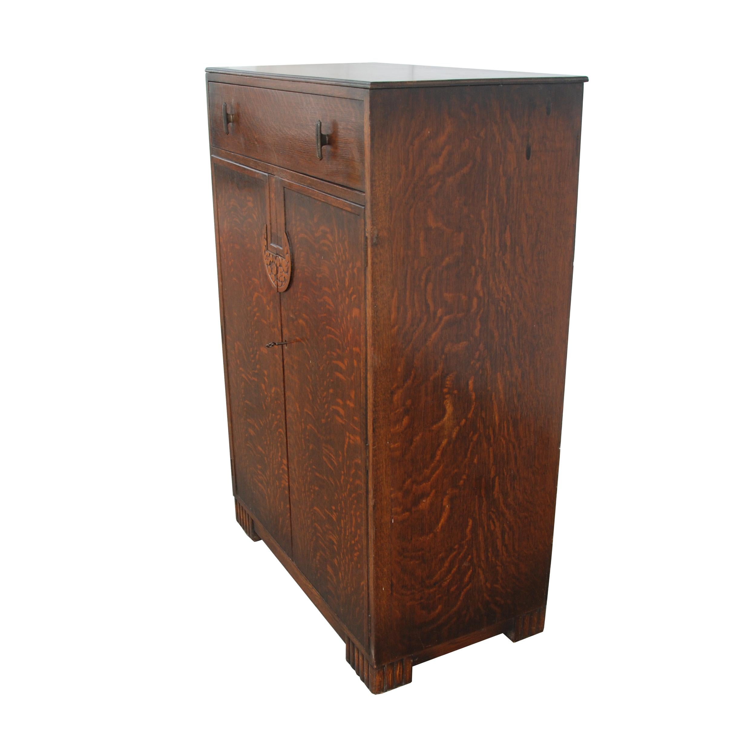 Art Deco Tiger Oak Cabinet

Features a light gold finish on interior shelves, as well as a locking mechanism with key for the large cabinets. Top drawers do not lock. 

Carved wood on handles and legs.
