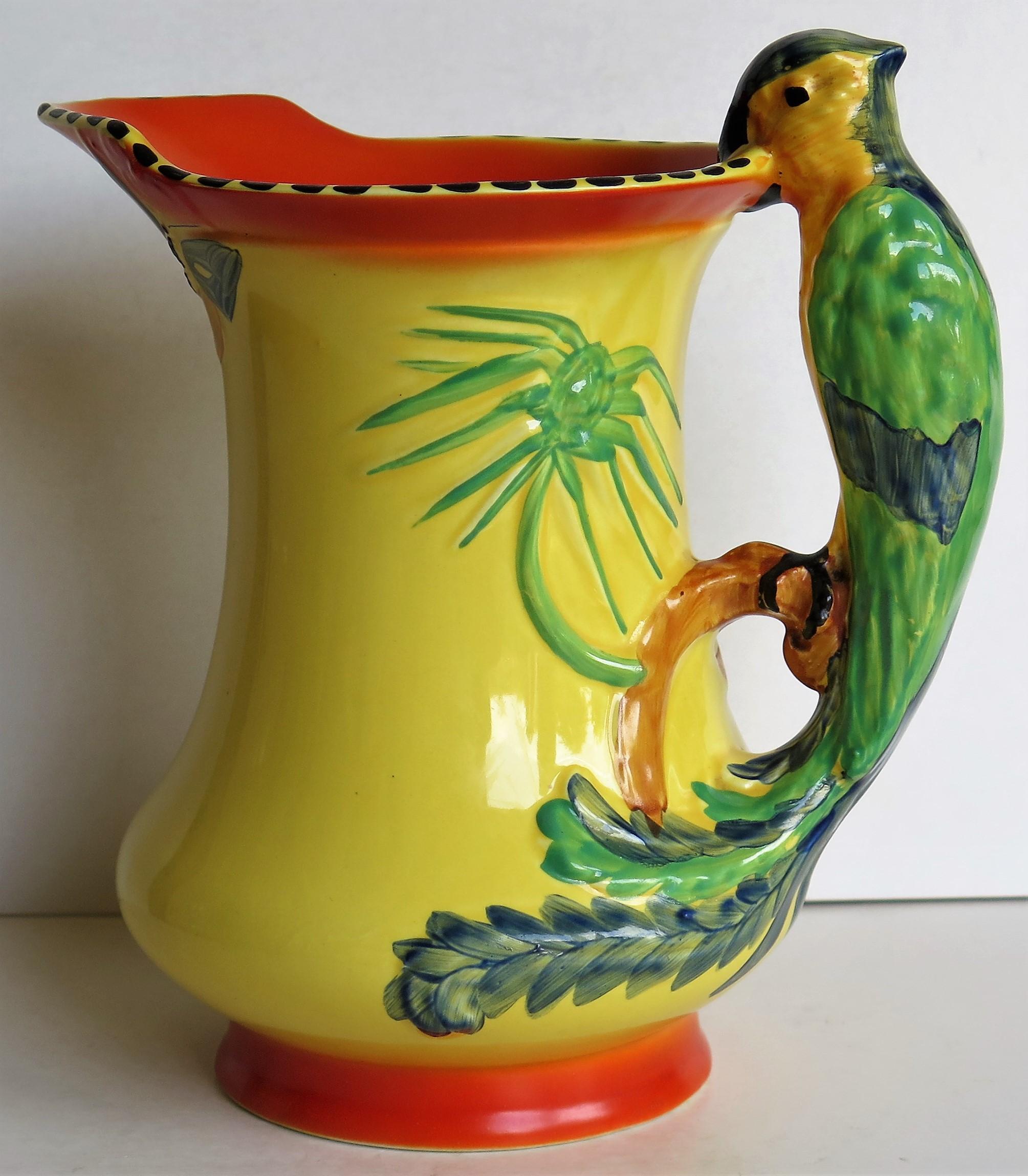 This is a very decorative Burleigh Ware pottery jug or pitcher made by Burgess and Leigh of Burslem, Staffordshire Potteries, England during the Art Deco period, circa 1930.

The jug has an interesting shape with a Parrot handle, moulded leaves