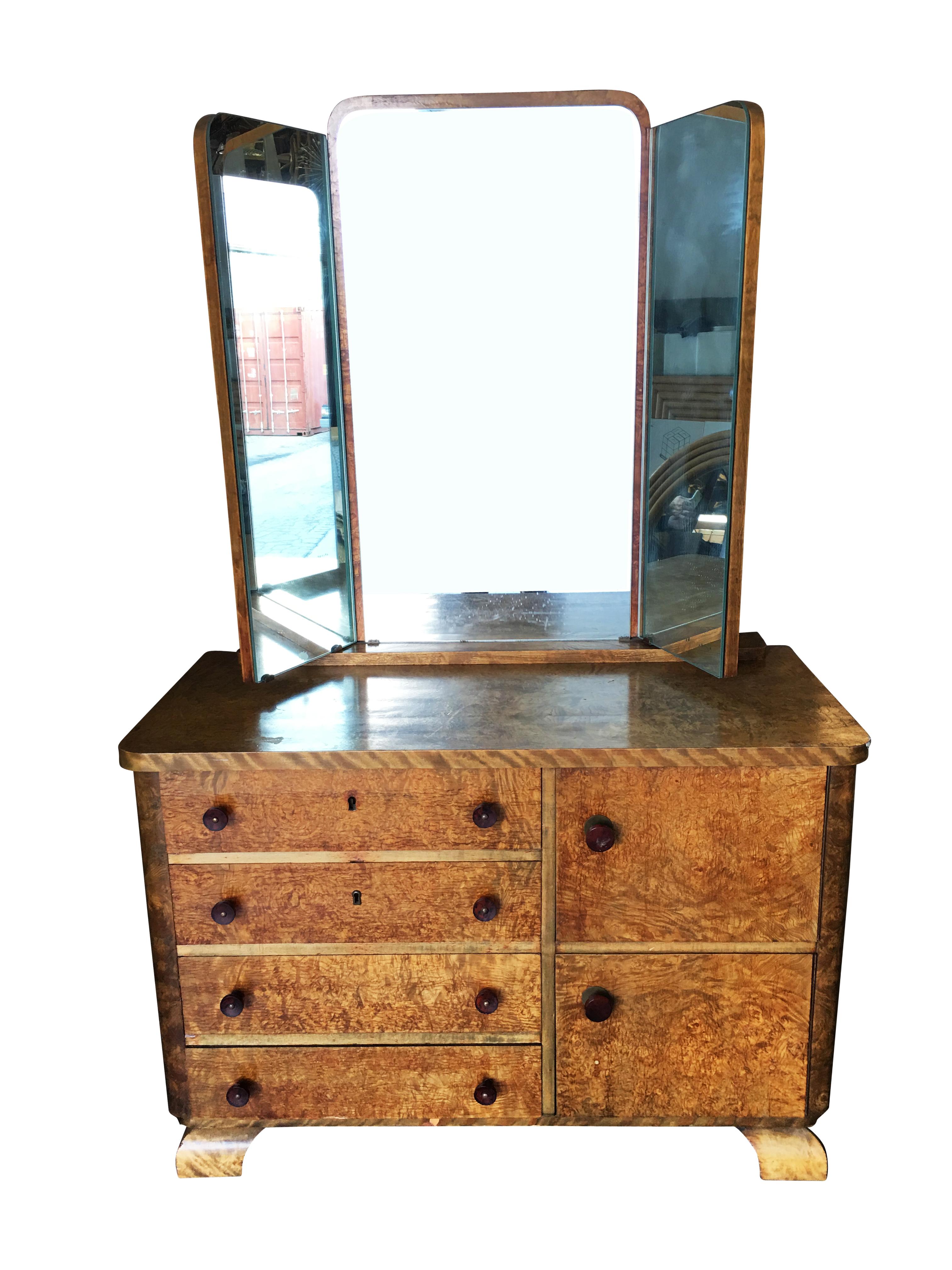 Vintage Art Deco burl wood dresser with tri fold mirror and clear celluloid handles. The dresser features four drawers and 2 small cabinets.