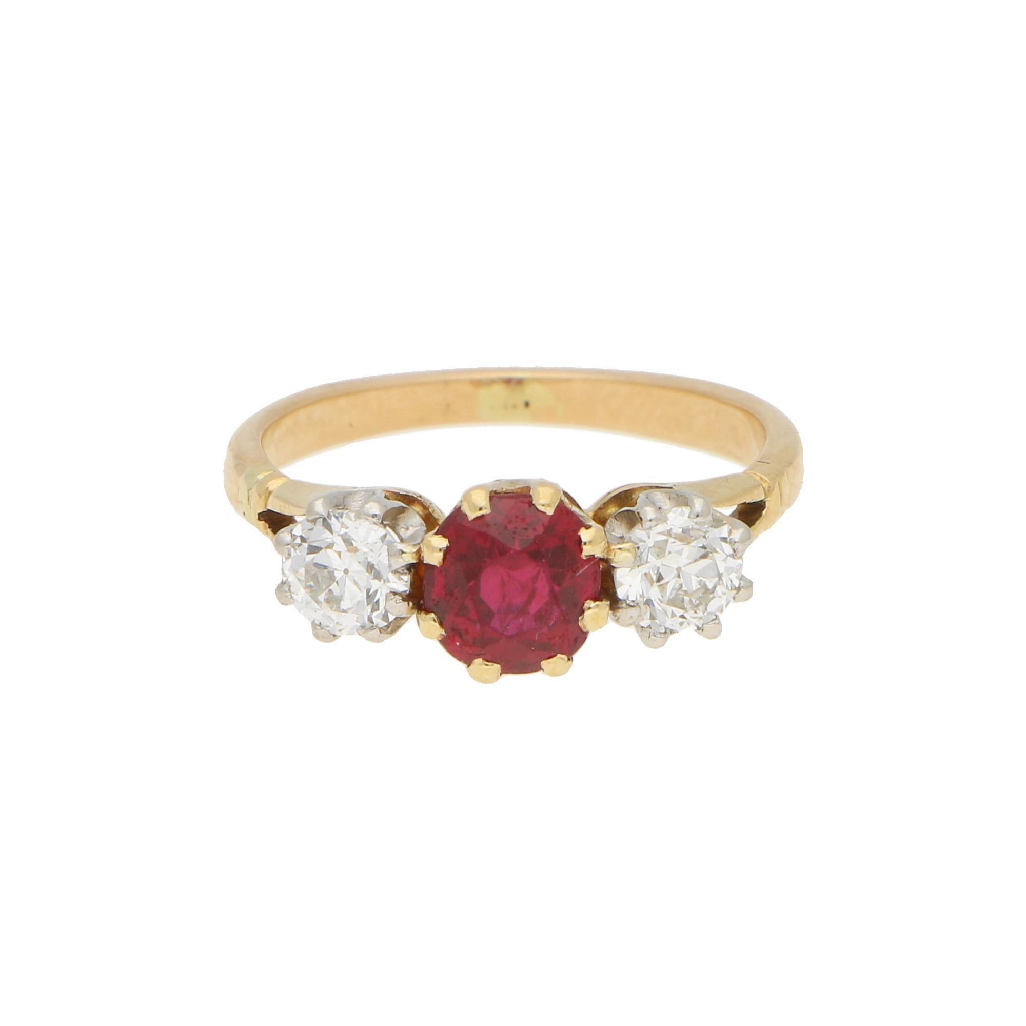 A beautiful late Art Deco ruby and old mine cut diamond trilogy engagement ring set in 18k yellow and white gold.

This classic design of engagement ring is centrally set with a round cut ruby which is a beautiful Burmese red colour. This ruby is