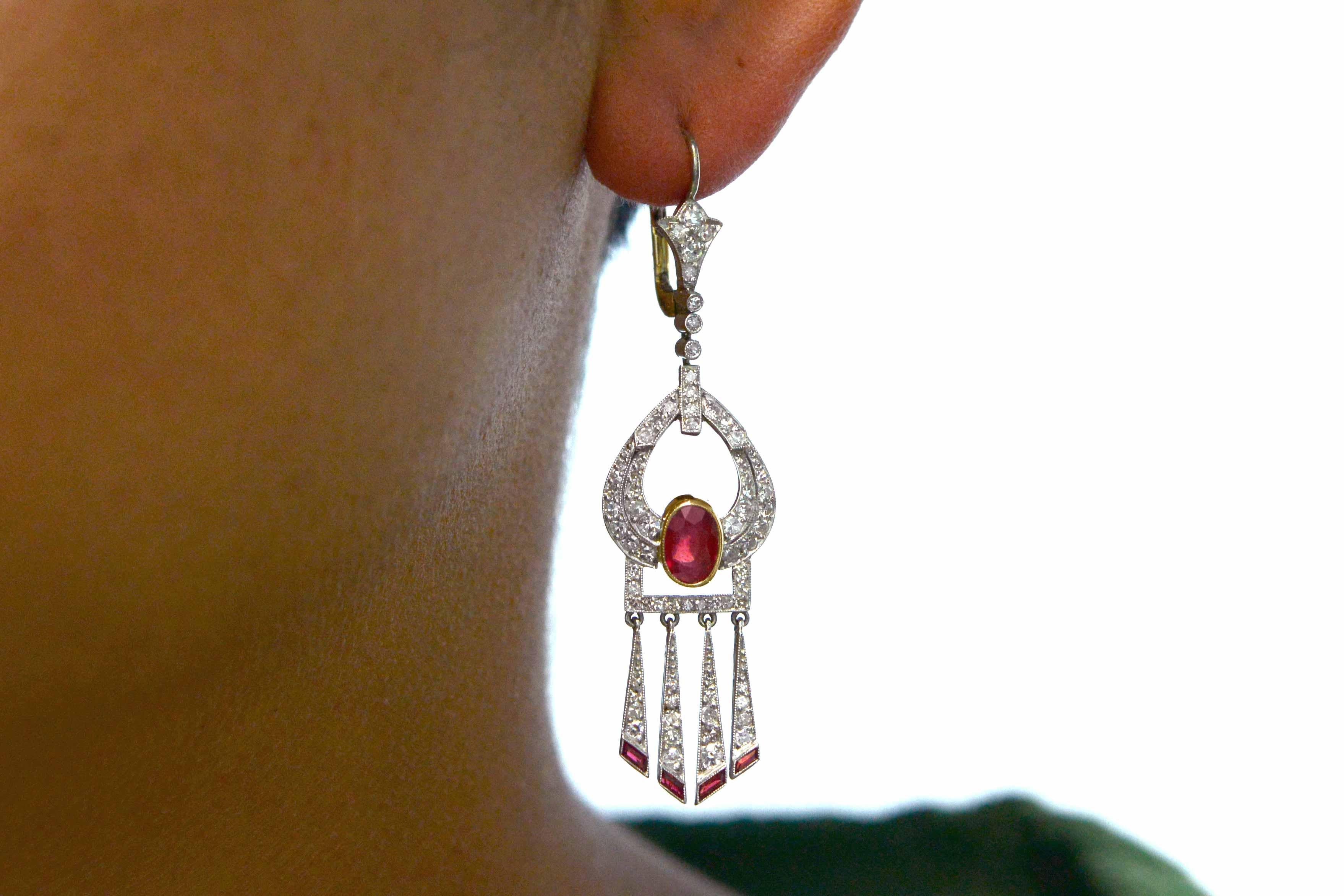 An exciting pair of authentic Art Deco ruby and diamond drop earrings. Centered by luscious, rich red Burmese rubies over 1 carat each and surrounded by an intricate, milgrain frame studded with nearly 2 carats of sparkling old cut diamonds. The