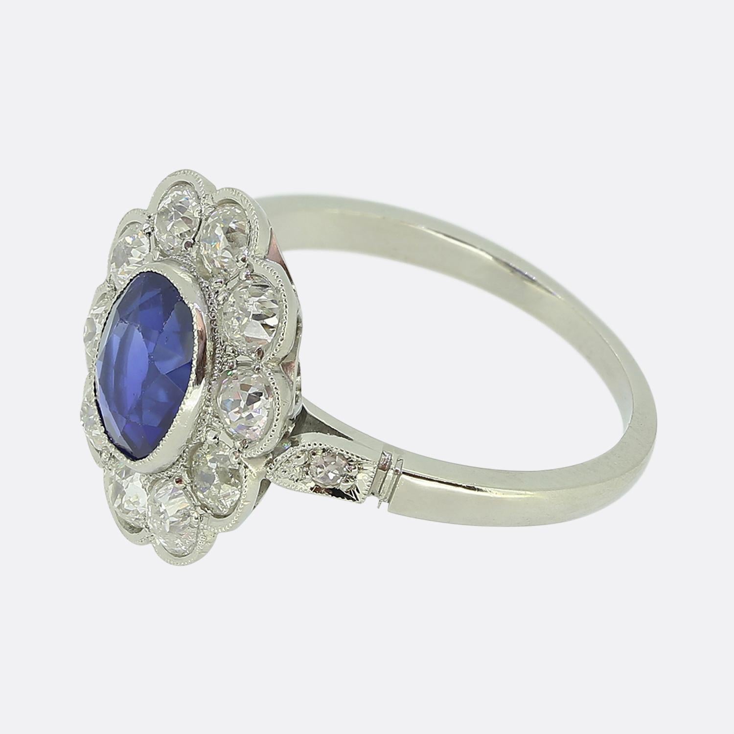 Hier haben wir einen auffälligen Saphir- und Diamant-Cluster-Ring aus der Zeit des Art déco. In der Mitte des Zifferblatts befindet sich ein beeindruckender ovaler, facettierter burmesischer Saphir von 1,20 Karat mit einem kräftigen, marineblauen