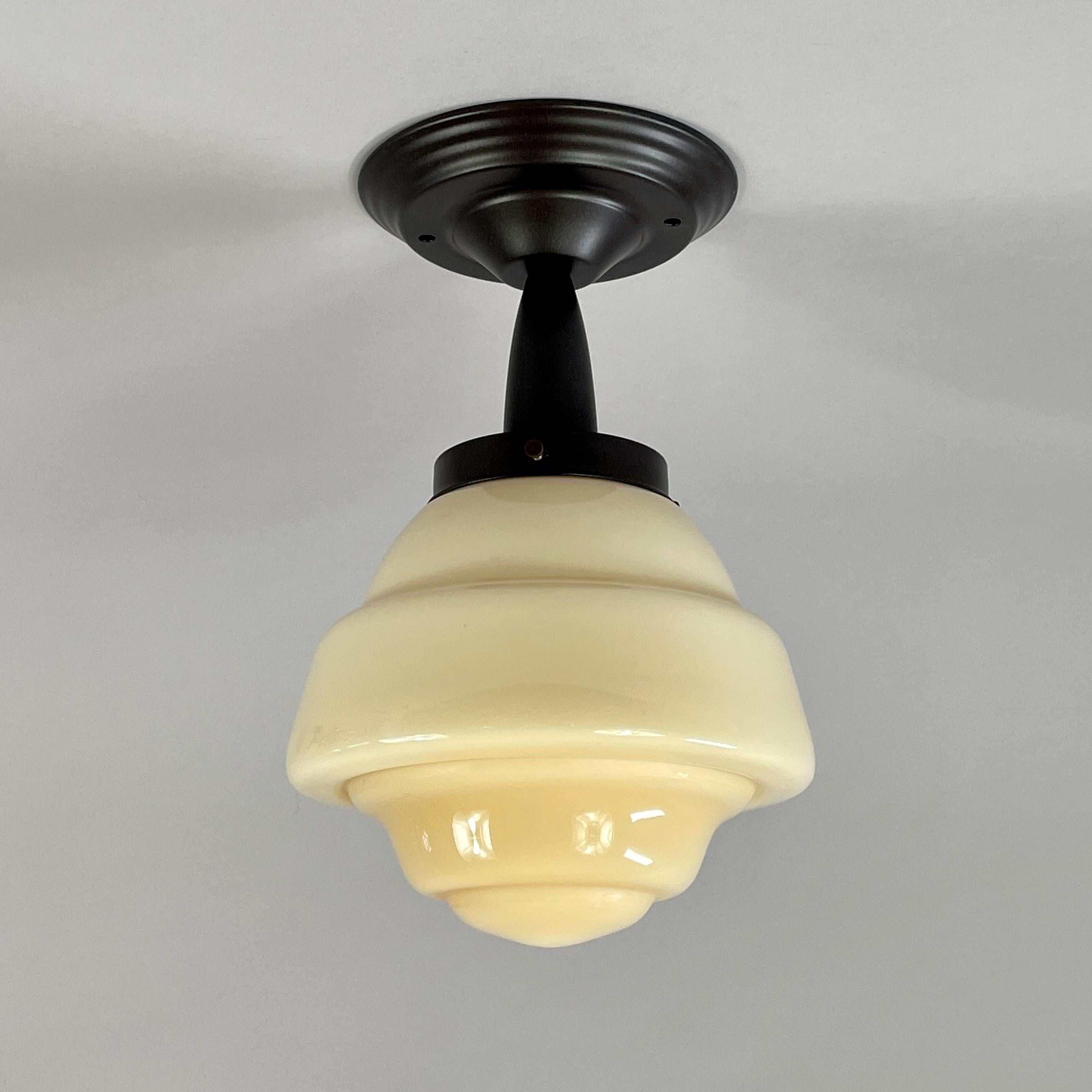 Cette applique Art déco a été conçue et fabriquée en Suède dans les années 1940.

La lampe est dotée d'un abat-jour sculptural en verre étagé dans un ton crème chaud, formant une silhouette étagée en forme de ruche, typique du design de la fin de