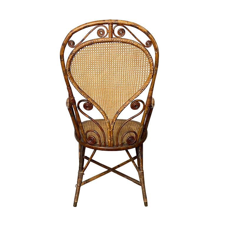 A gorgeous art deco burnt bamboo armchair. A stunning example of craftsmanship during the era, this piece is created from a mixture of cane, rattan, and burnt bamboo or 