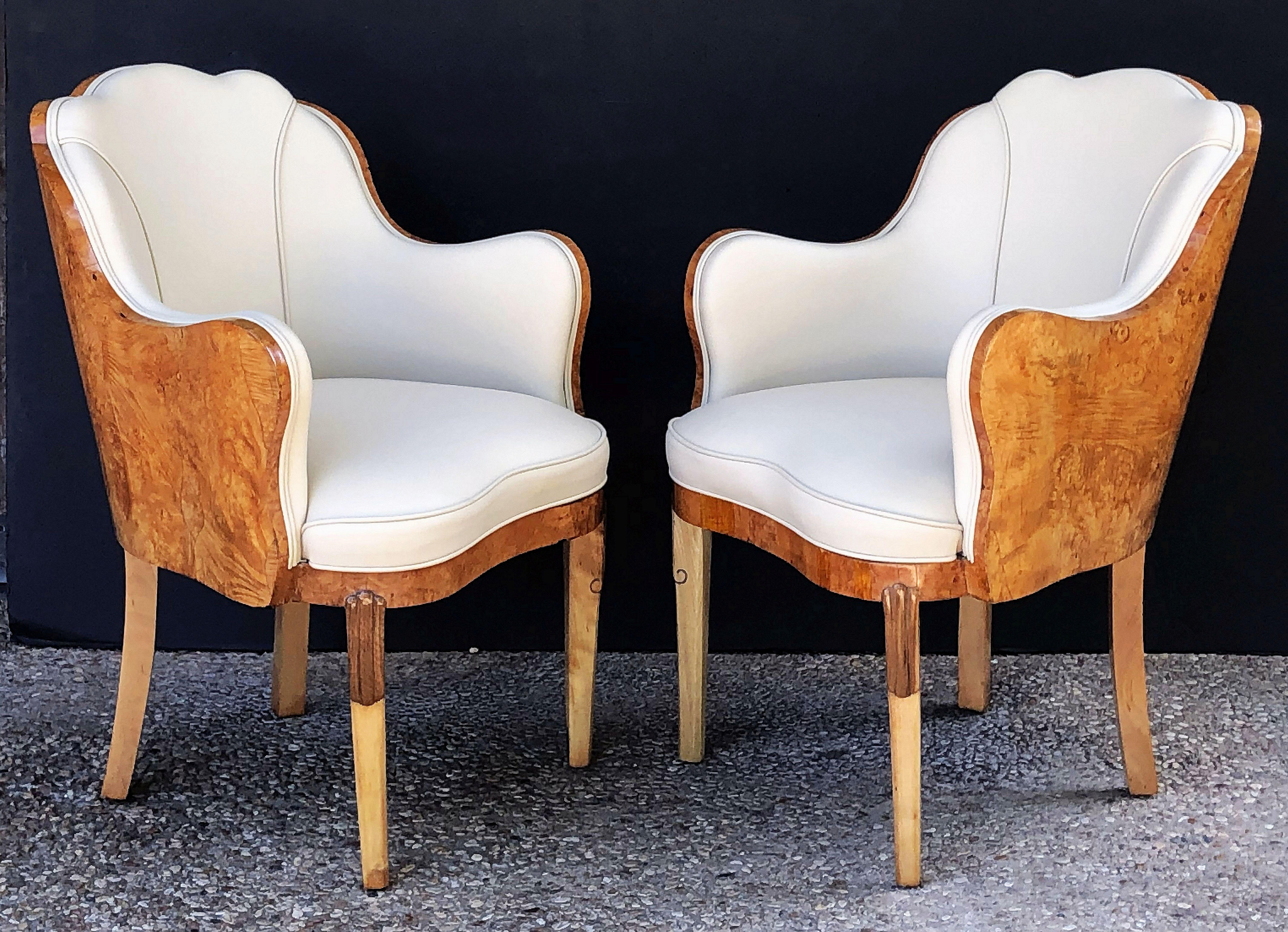A fine pair of Art Deco era chairs or armchairs, circa 1930, by the celebrated designer, Maurice Adams, each chair featuring burr walnut wraps and upholstered cream leather, with a serpentine shape back and comfortable seats.

Individually priced