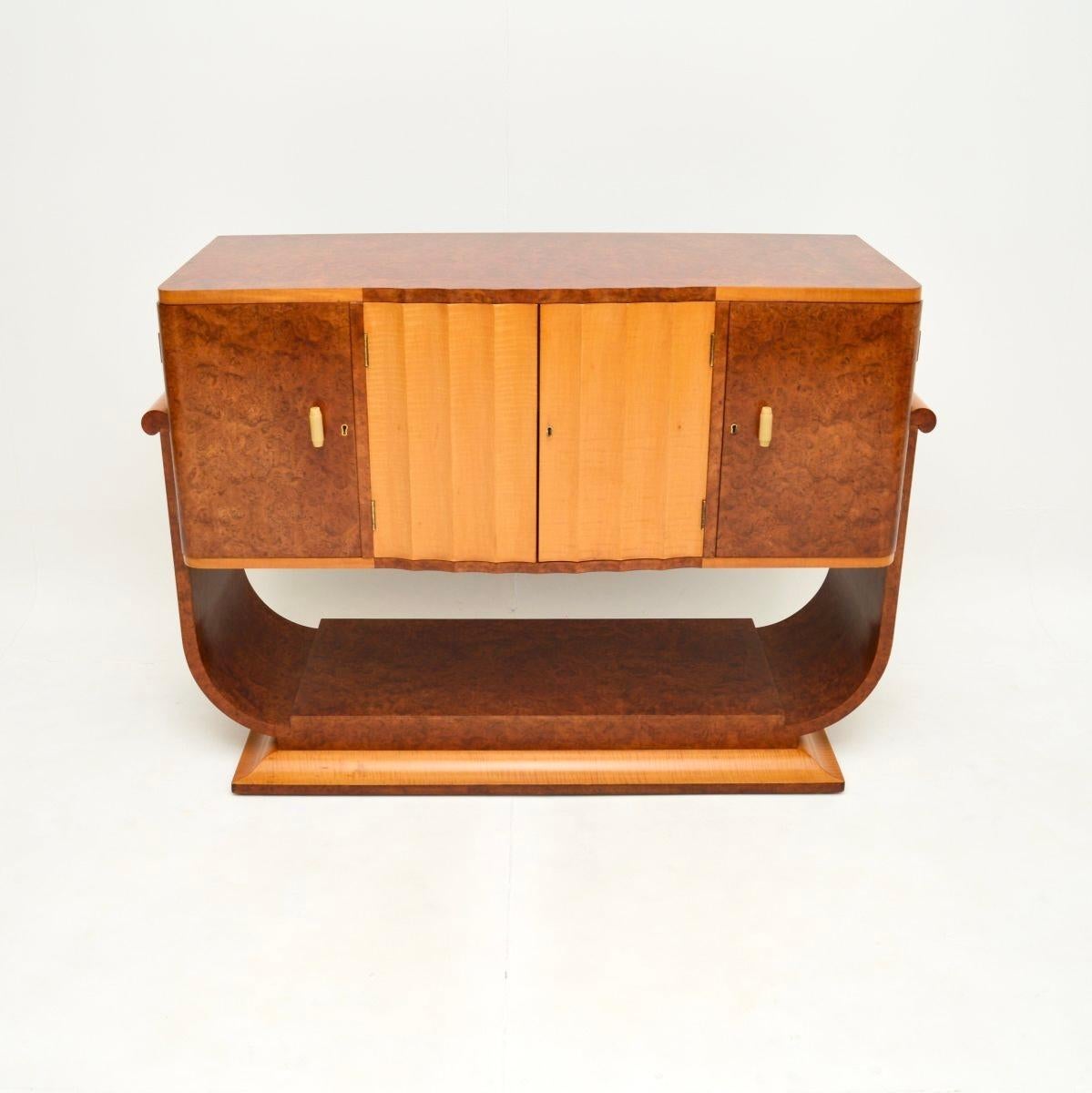 A gorgeous original Art Deco burr walnut and sycamore sideboard, made in England and dating from the 1930’s.

This is of outstanding quality, it is beautifully crafted and has a very stylish design. It stands on a U shaped base with a useful