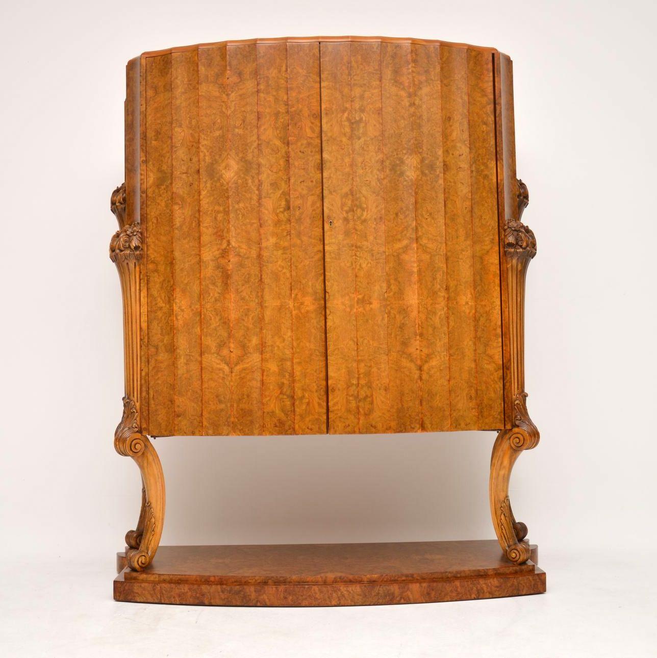 A magnificent and rarely seen original Art Deco period cocktail cabinet in burr walnut, this was designed and made by Harry & Lou Epstein in the 1930s. It is of amazing quality, with stunning walnut veneers and beautiful floral carving. The doors
