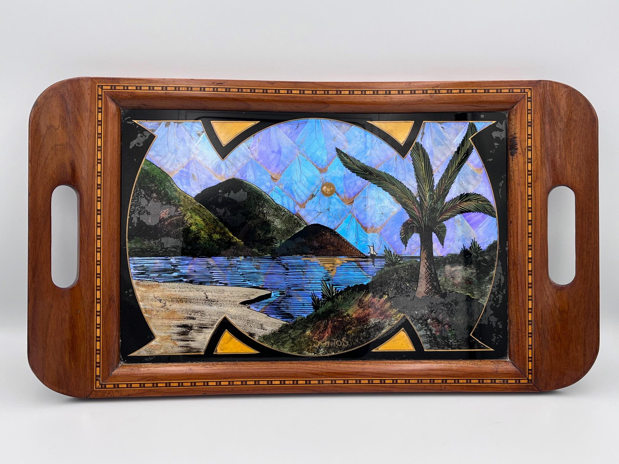 Plateau à ailes de papillon brésilien des années 1930 de Santos, Brésil

Cet exquis plateau brésilien des années 1930 est un magnifique exemple de l'art traditionnel des ailes de papillon. Il présente une scène de paysage sous verre magnifiquement