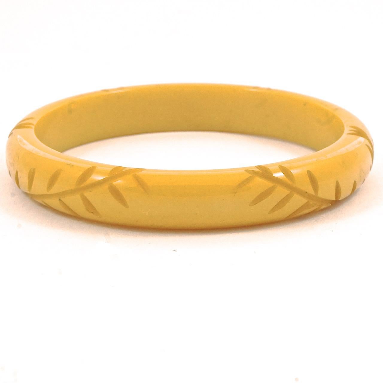 Meraviglioso braccialetto in bachelite Art Deco di colore giallo burro con un grazioso intaglio di foglie. Diametro interno 6,3 cm / 2,5 pollici e larghezza 1 cm / .4 pollici. Il braccialetto è in ottime condizioni.

Si tratta di un bellissimo