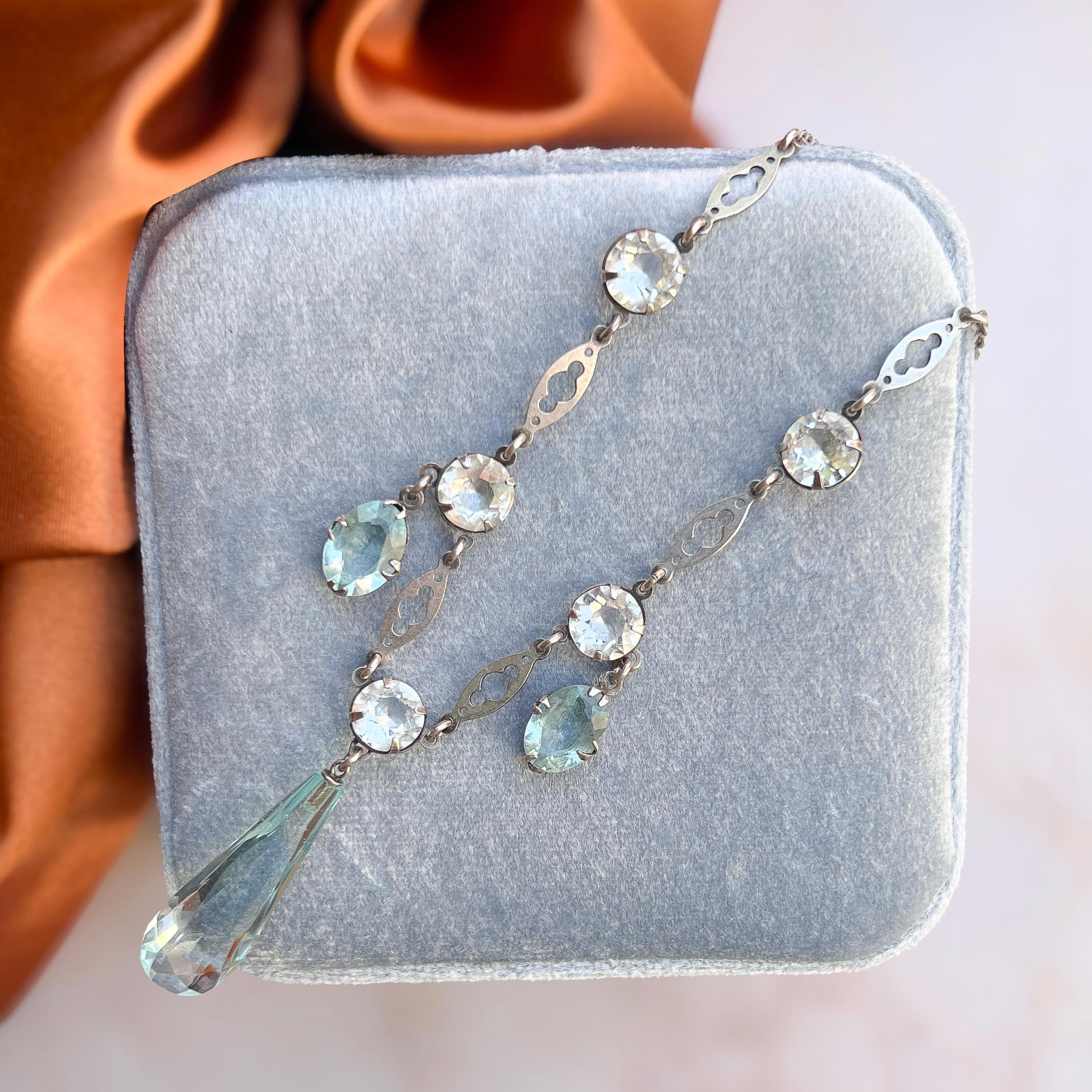 This elegant necklace was created in c.1930. 

Condition Report:
Excellent

The Details...
This necklace is constructed from silver tone metal and features a delicate cable chain. Suspended from the centre of the necklace is a faceted aquamarine