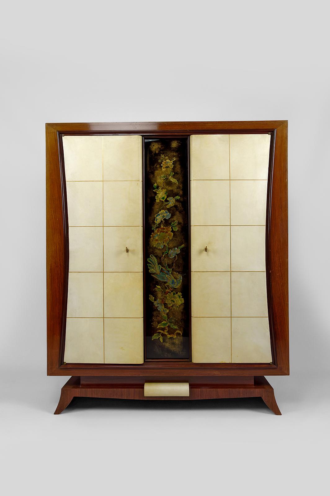 Mahogany veneer
2 doors covered in vellum leather, squared with gilding.

In the center, églomisé/painted glass plaque depicting a majestic bird on a branch, surrounded by Japanese-style flowers.

2 keys, locks OK.
2 shelves

Art Deco, France, circa