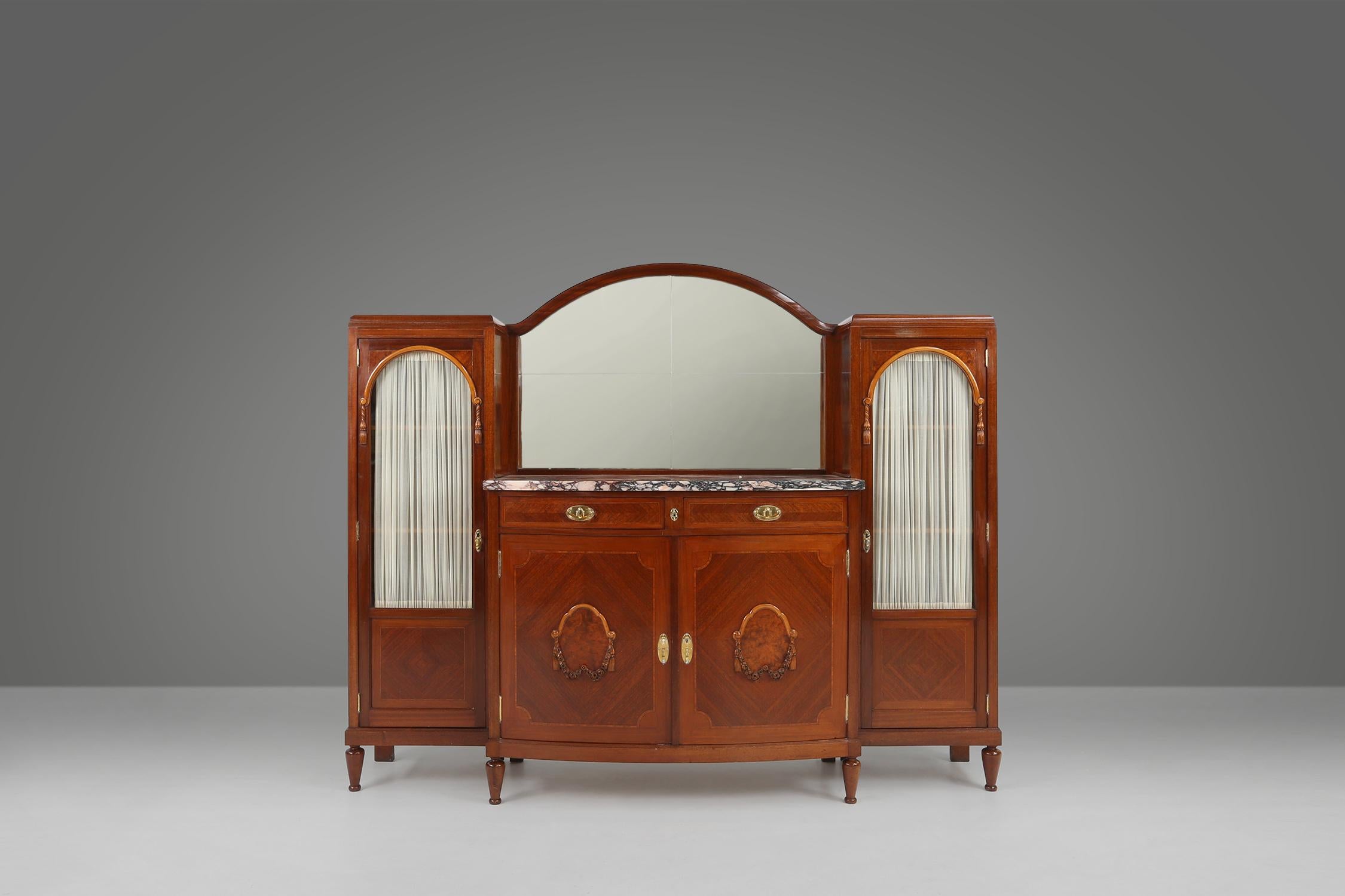 Cette armoire a été fabriquée en 1930 par De Coene en Belgique. Fabriqué en matériaux de haute qualité et en excellent état.

L'armoire est dotée de deux armoires latérales en verre et d'un rideau à l'arrière. Au milieu, vous trouverez un meuble