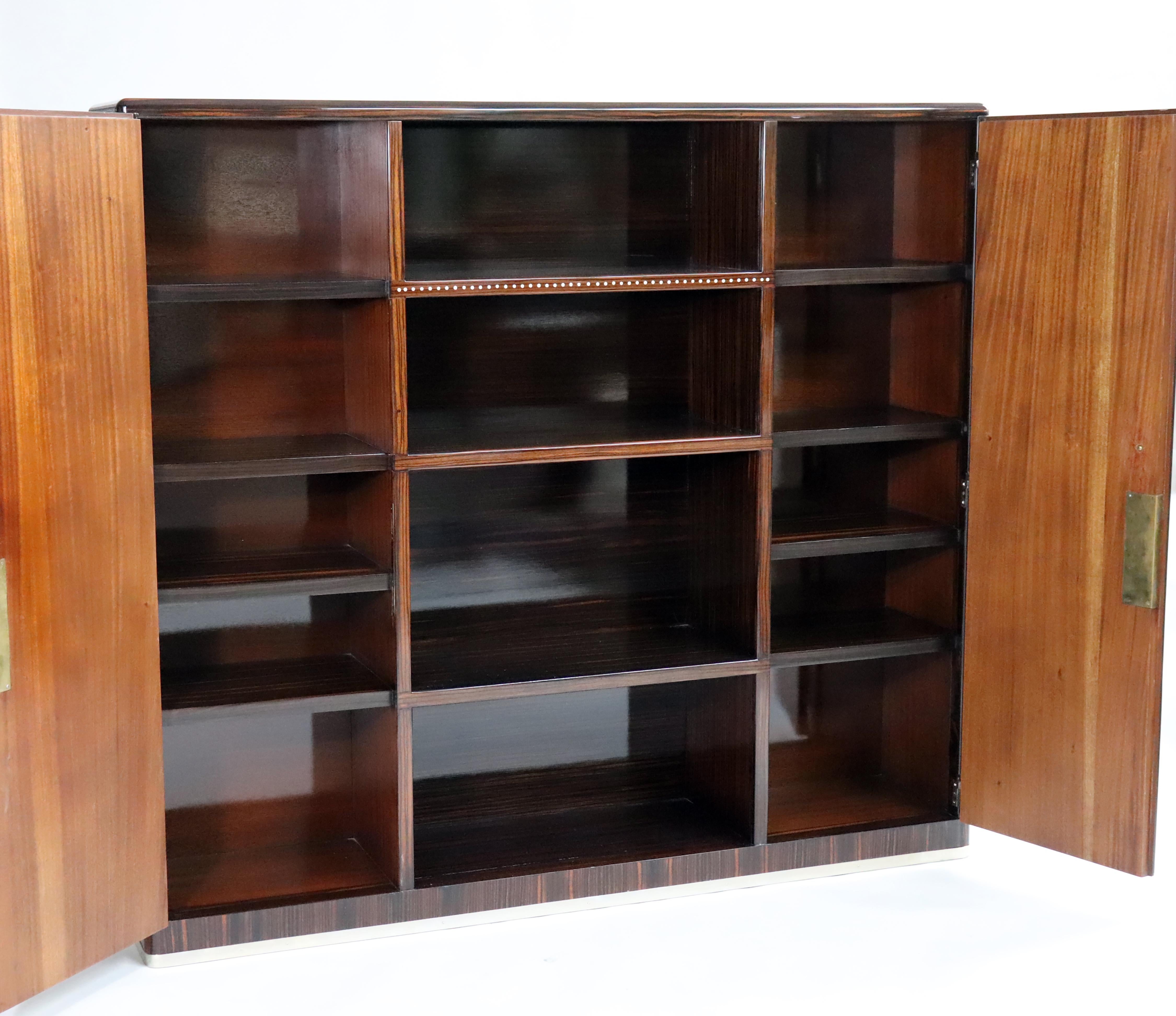 French Art Deco cabinet in walnut wood in high gloss with Nickel Bronze hardware and Mother of Pearl inlays. This Cabinet was designed by Maurice Rinck in 1935. Made in France.