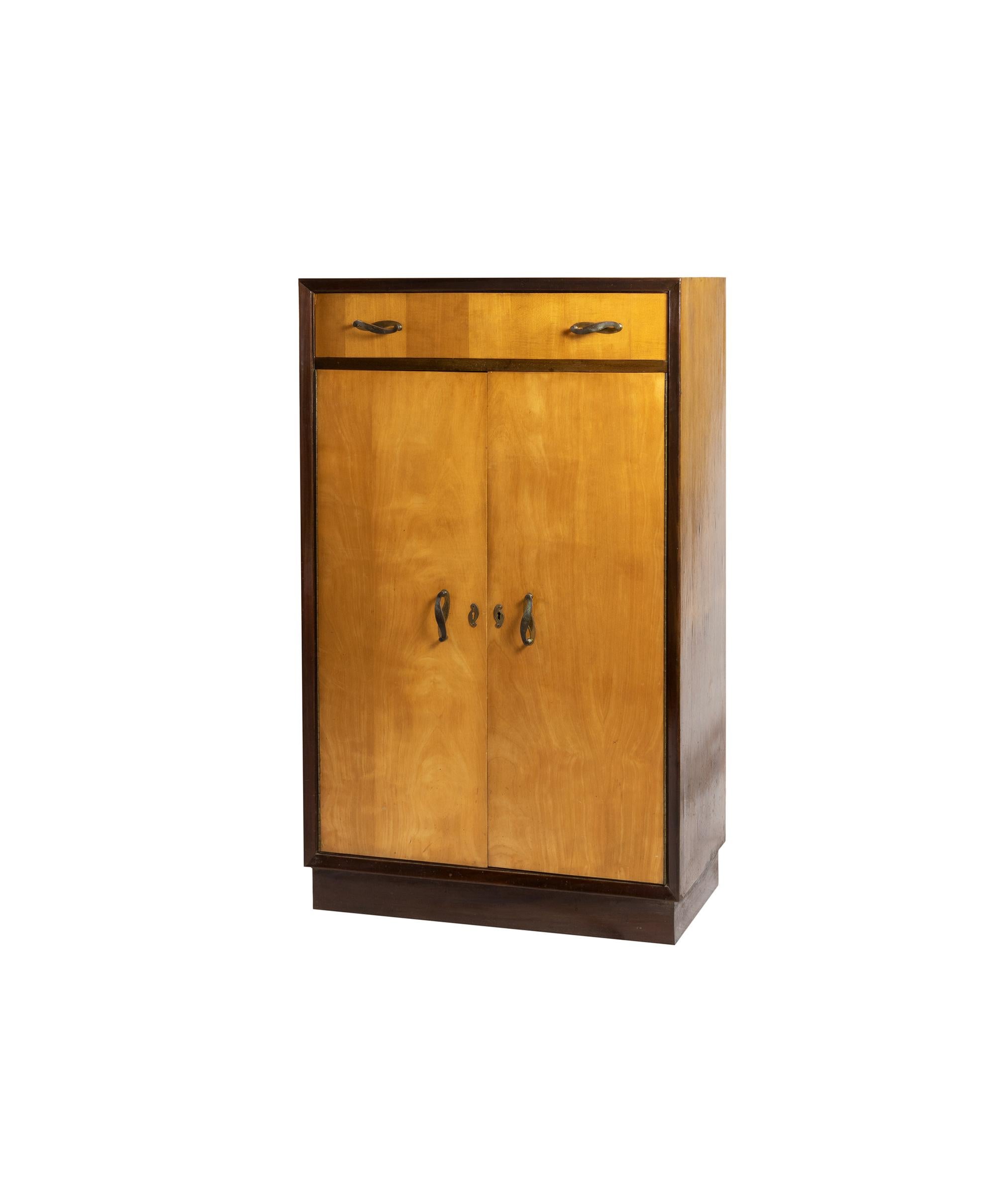 This cabinet features a drawer and five shelves. It was crafted in the parish of Bonfim, Porto, Portugal, by Armazéns Nascimento, and is adorned with brass handles. 

In Porto, pieces like this were designed for Art Deco apartment blocks in Largo de