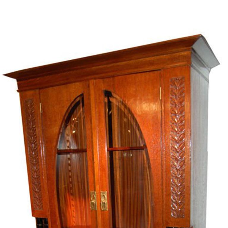 Cabinet Art Déco en noyer et bois ébène avec quincaillerie en laiton, portes vitrées et étagères intérieures.