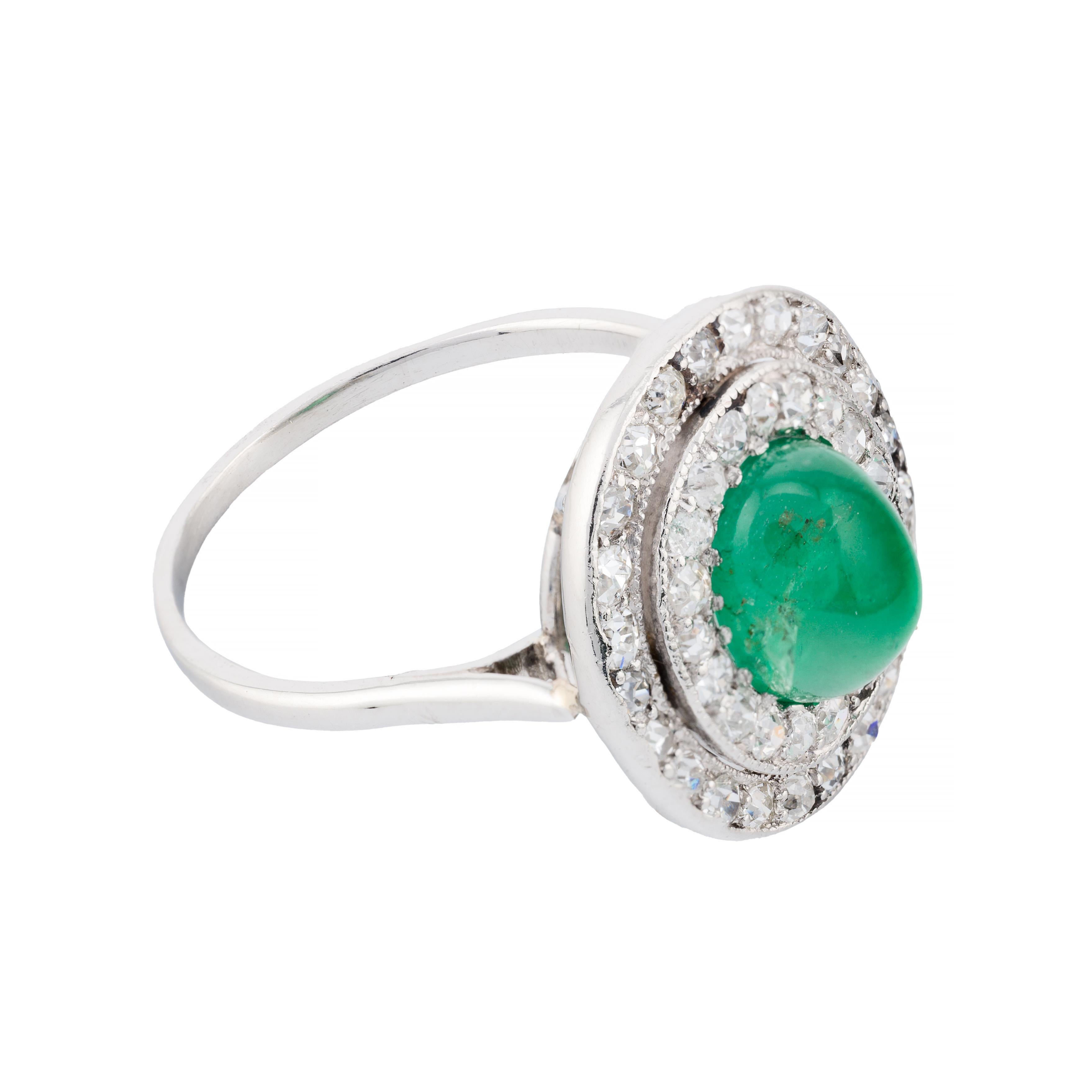 Aston Estate Jewelry presenta:

Un affascinante anello aureola art déco con uno smeraldo cabochon da 1,75 carati che emana una vibrante tonalità verde. Il centro è graziosamente circondato da una doppia aureola di diamanti taglio old mine. I