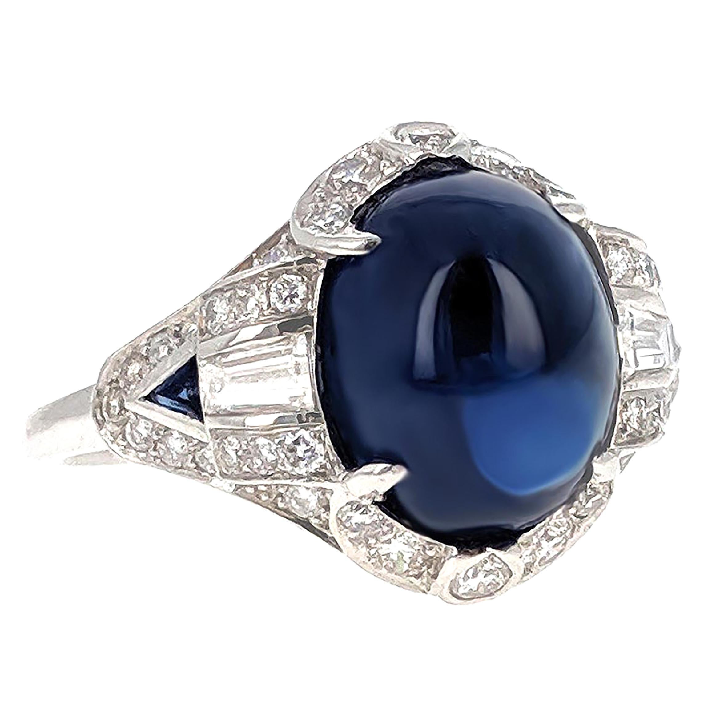 This ring centers upon a cabochon sapphire weighing approximately 6.20 carats. It is  framed by round diamonds, accented by baguette diamonds, and further set with two triangle-shaped sapphires. It is mounted in platinum and created circa 1930.

The