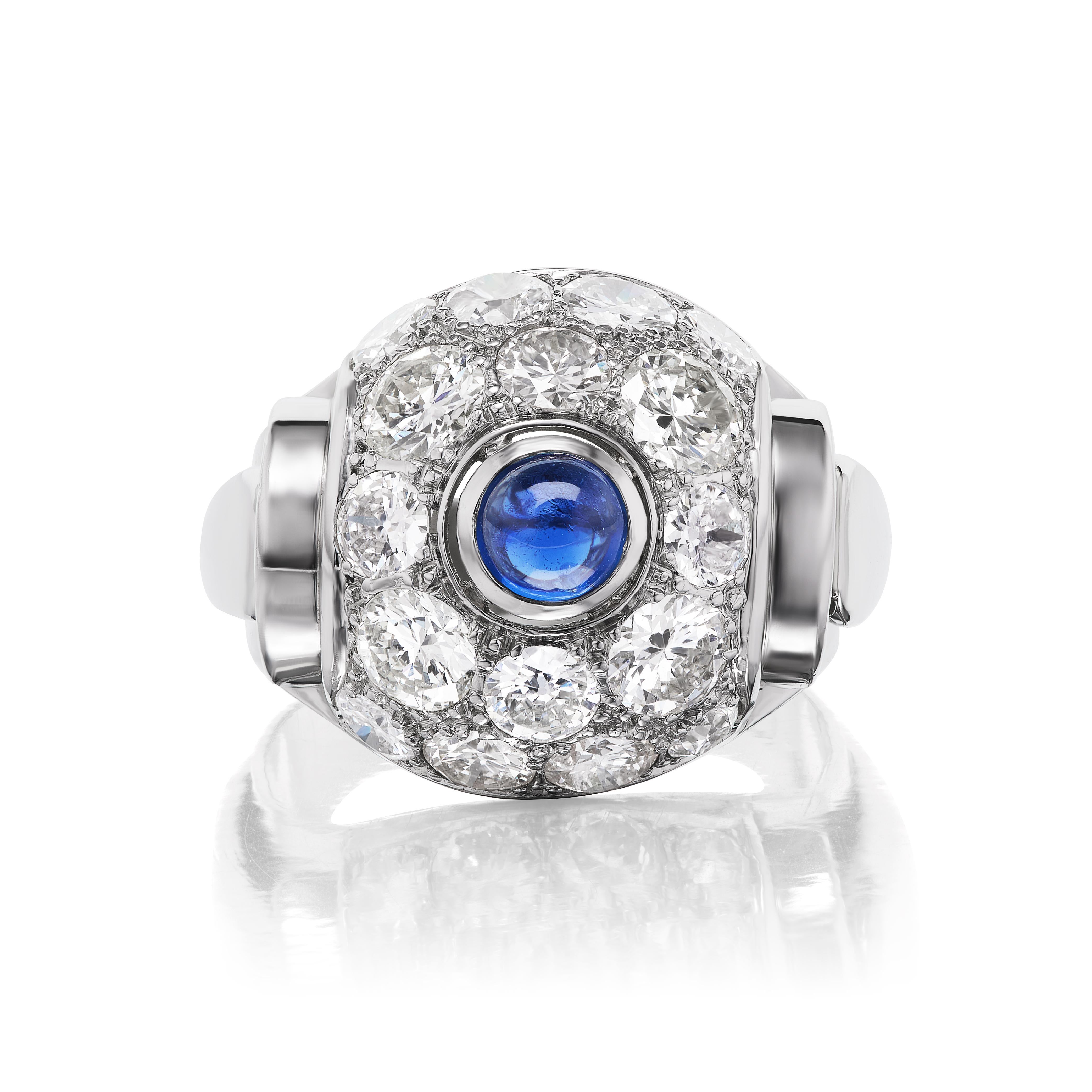 This wonderful and charming Art Deco ring features a pleasant .25 carat cabochon sapphire set in an impressive meadow of 16 round brilliant diamonds weighing approximately 3.20 carats. Set in platinum in very good condition, this ring is an