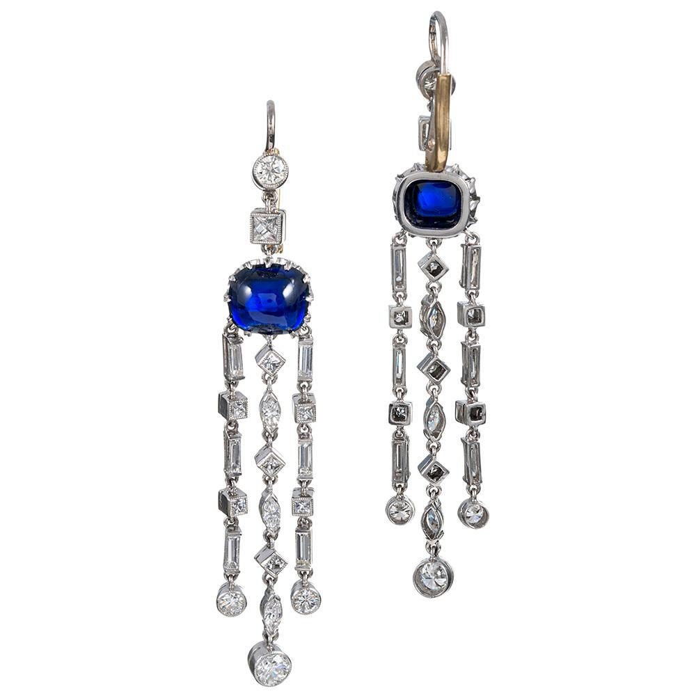 Intense blue cabochons of sapphire anchor the design of these flowing, feminine earrings. The stones are of magnificent quality and exhibit a truly delicious shade of medium blue. They weigh approximately 3.30 and 3.40 carats respectively. The