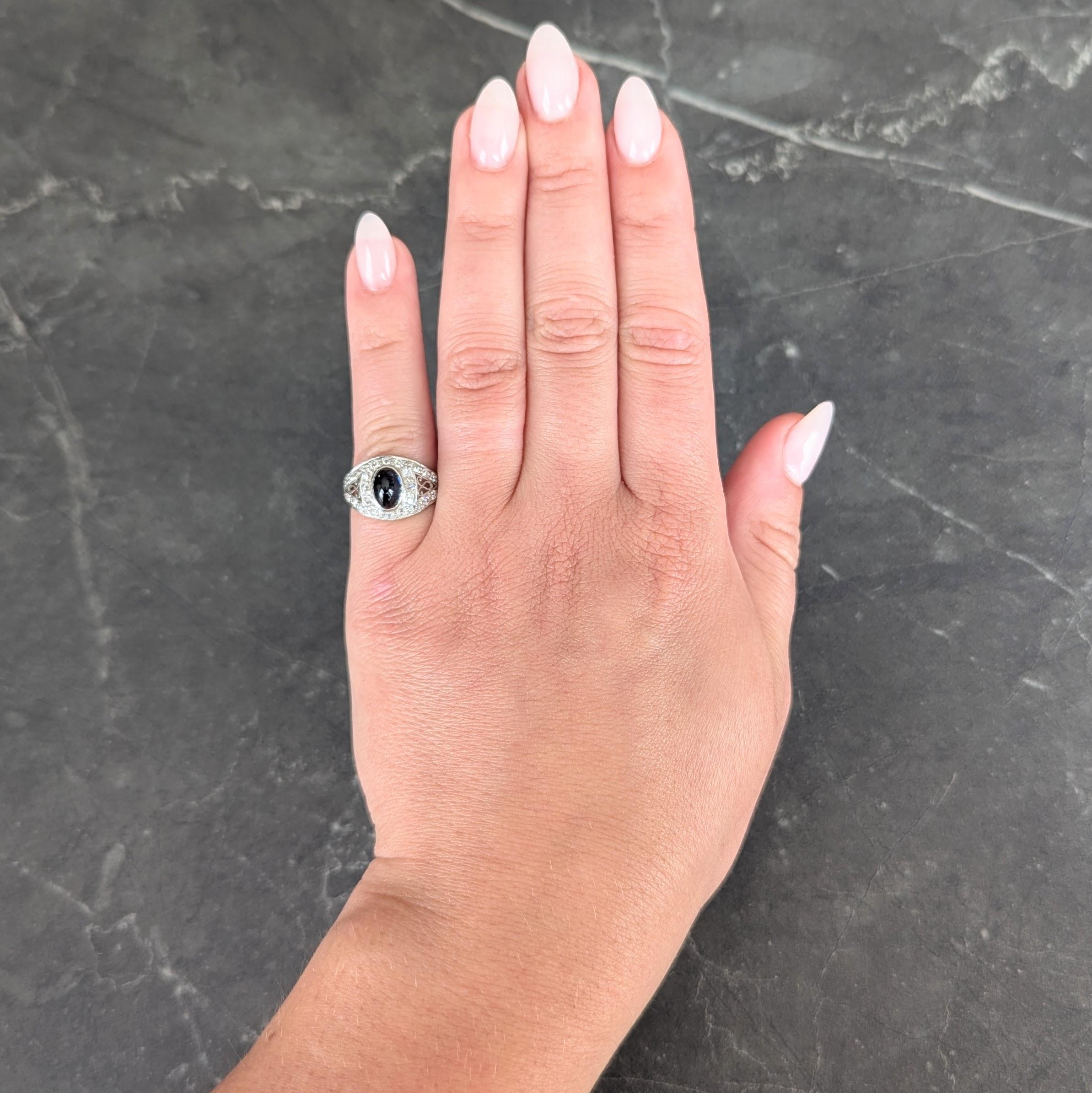 Centré sur un cabochon de forme ovale pesant environ 1,57 carats au total - couleur bleu foncé transparent
Lunette sertie d'un entourage de halo de diamants simples et de taille européenne ancienne formant une forme bombée.
Perle sertie d'un diamant