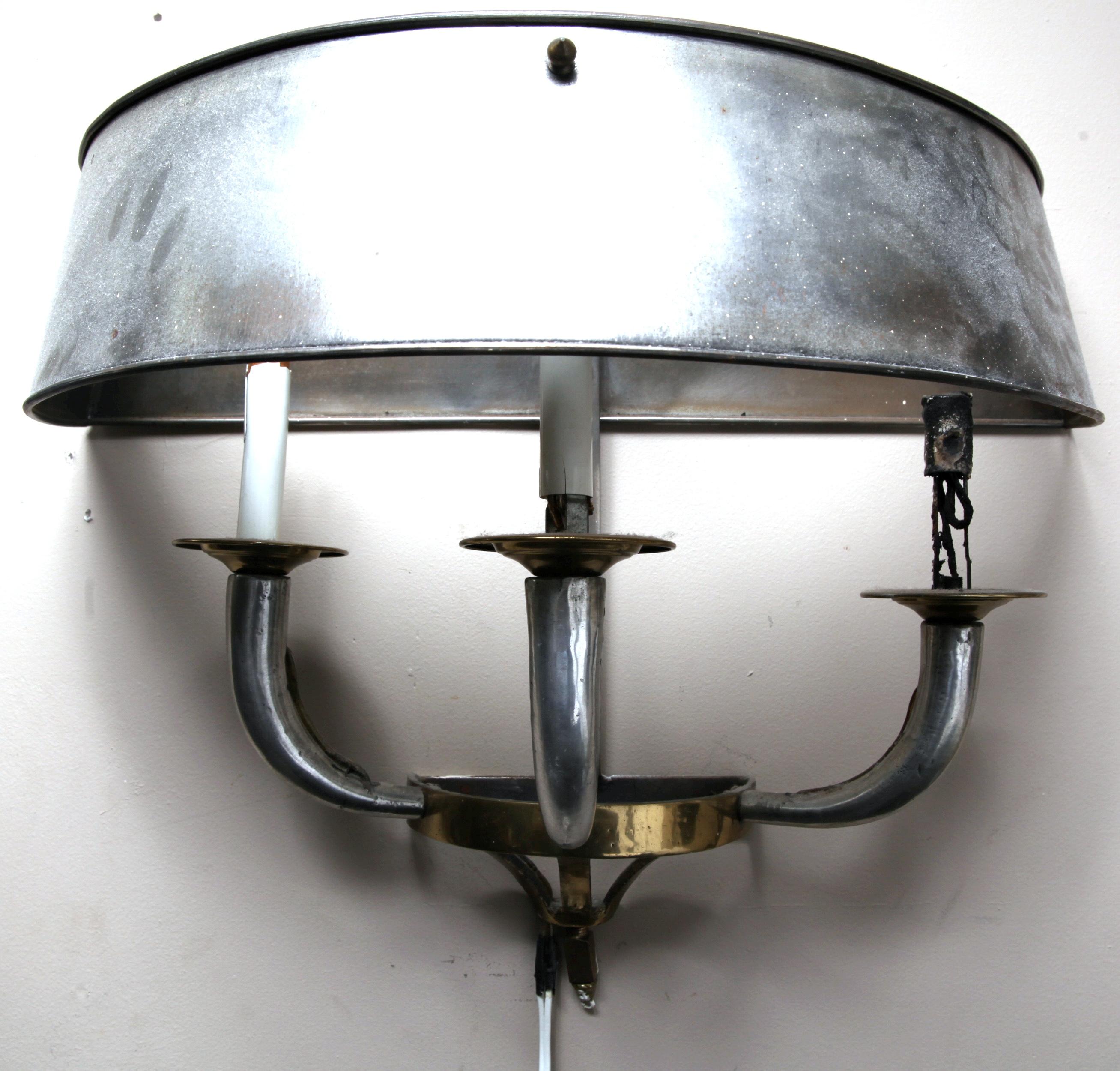 Pair of Art Deco mixed metal three light candelabra wall sconces with hemispherical metal shades. The pair is in great vintage condition with minor damages throughout.