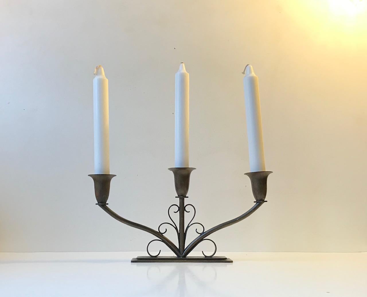 Balanced, stylized patinated bronze candelabra designed by Holger Fredericia and manufactured by Ildfast in Denmark during the early 1930s. Architecturally 'staired' base measuring 5 cm in dept. Is to fitted with 3 regular sized candles.