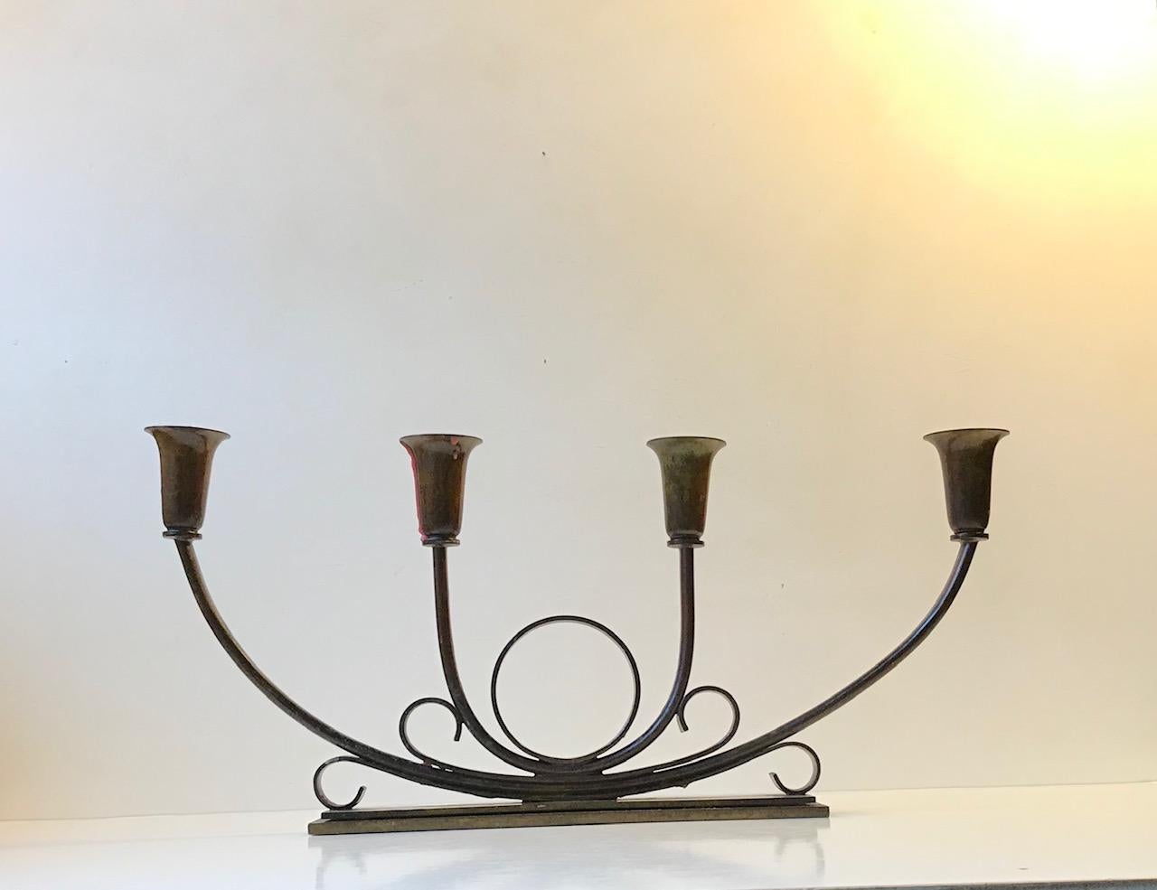 Superbly balanced and stylized bronze candelabra designed and manufactured by Ildfast in Denmark during the early 1930s. Architecturally 'staired' base measuring 23 x 5 cm. Is to fitted with 4 regular sized candles.