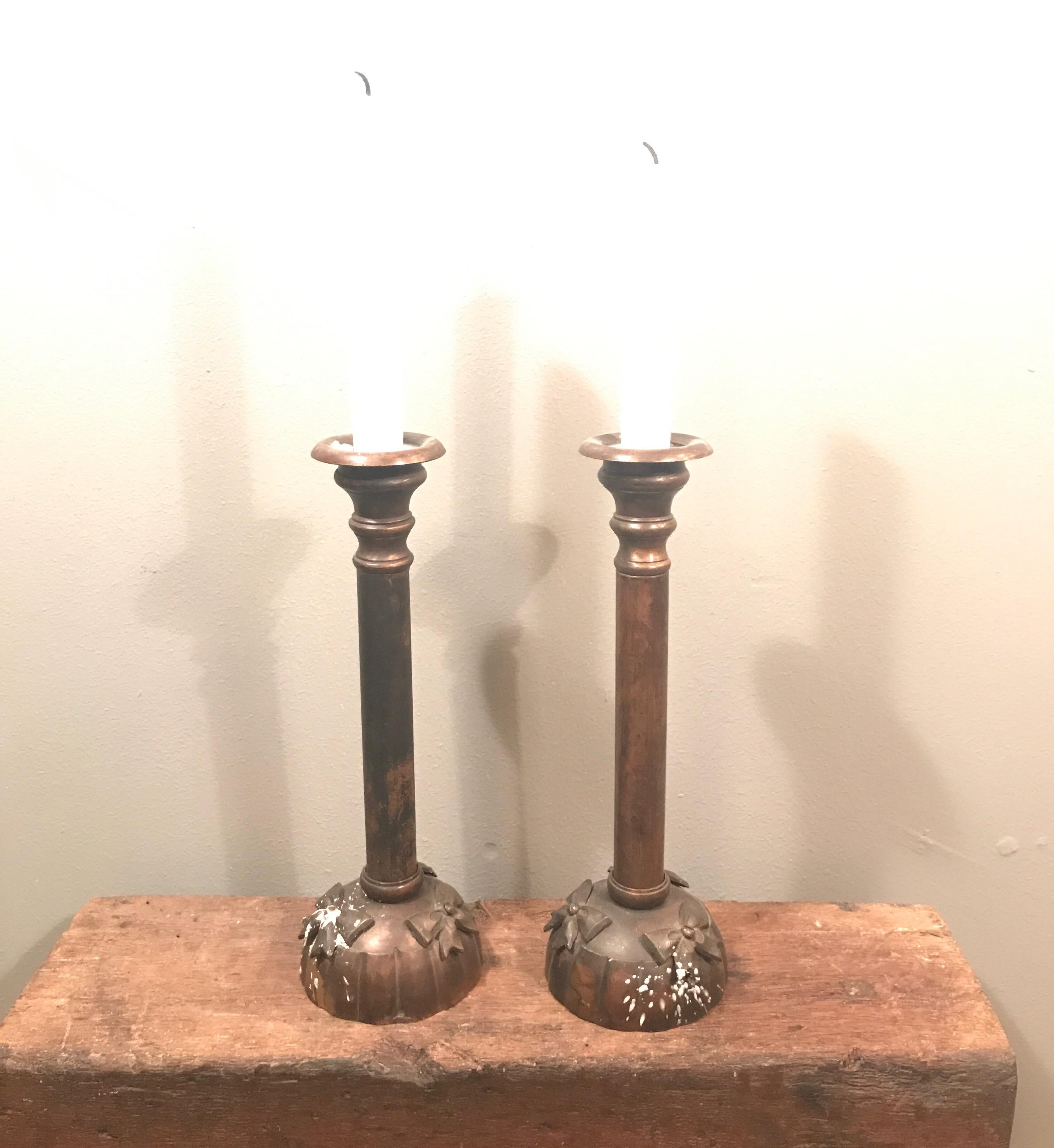 A lovely classic pair of Art Deco candleholders in what appears to be copper
Pressed base and decorated with 3 bows 
Very attractive patina.