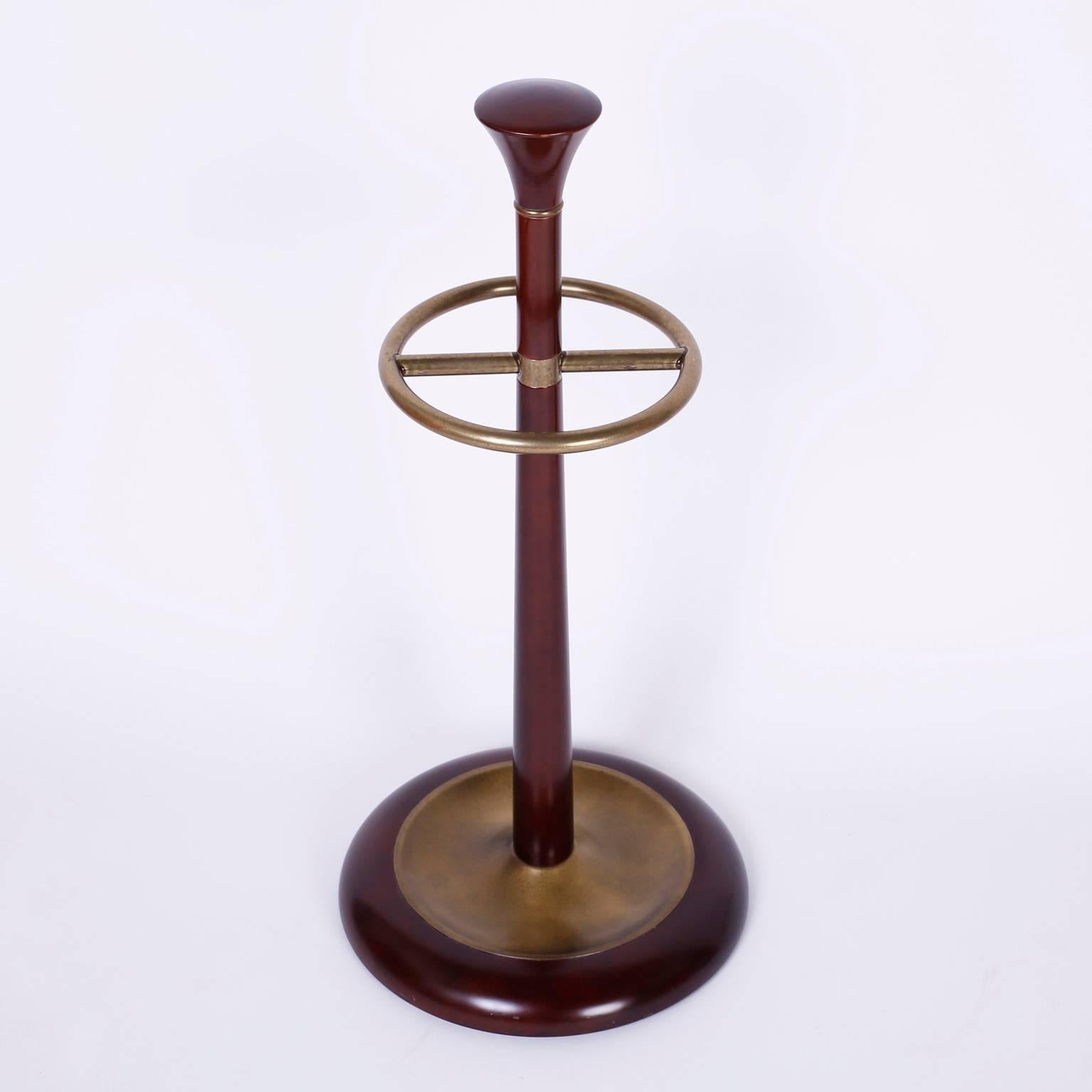 Art Deco cane or umbrella stand constructed with mahogany and brass and sporting a rather dapper form.