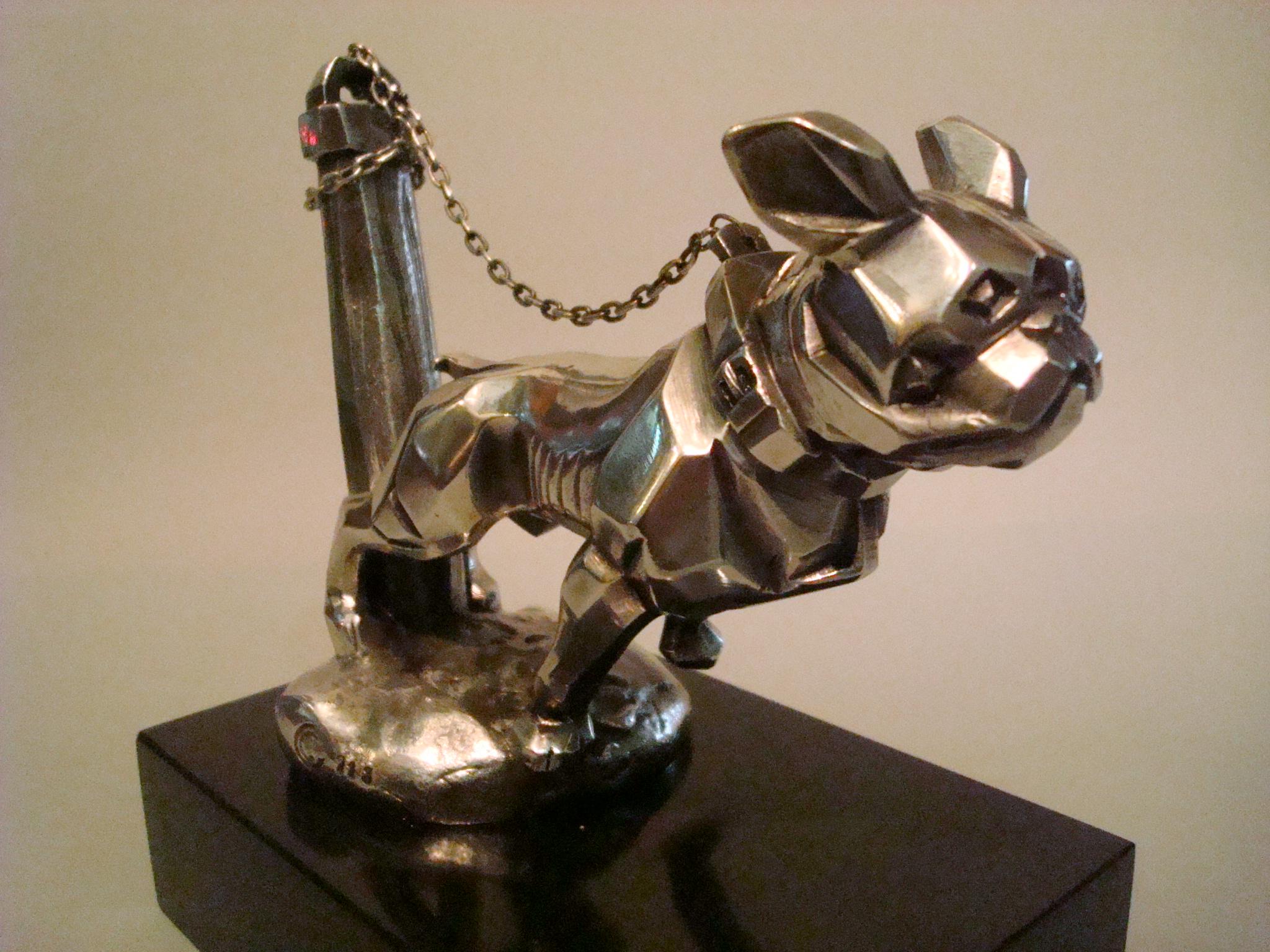 Art Deco 'Chained Bulldog' Car Mascot / Hood Ornament by Marvel, French, 1920´s,
marked with foundry stamp number 213, silver-plated bronze, large version, 14cm long, complete with chain. Very nice desk piece of Automobilia.

Some info on the