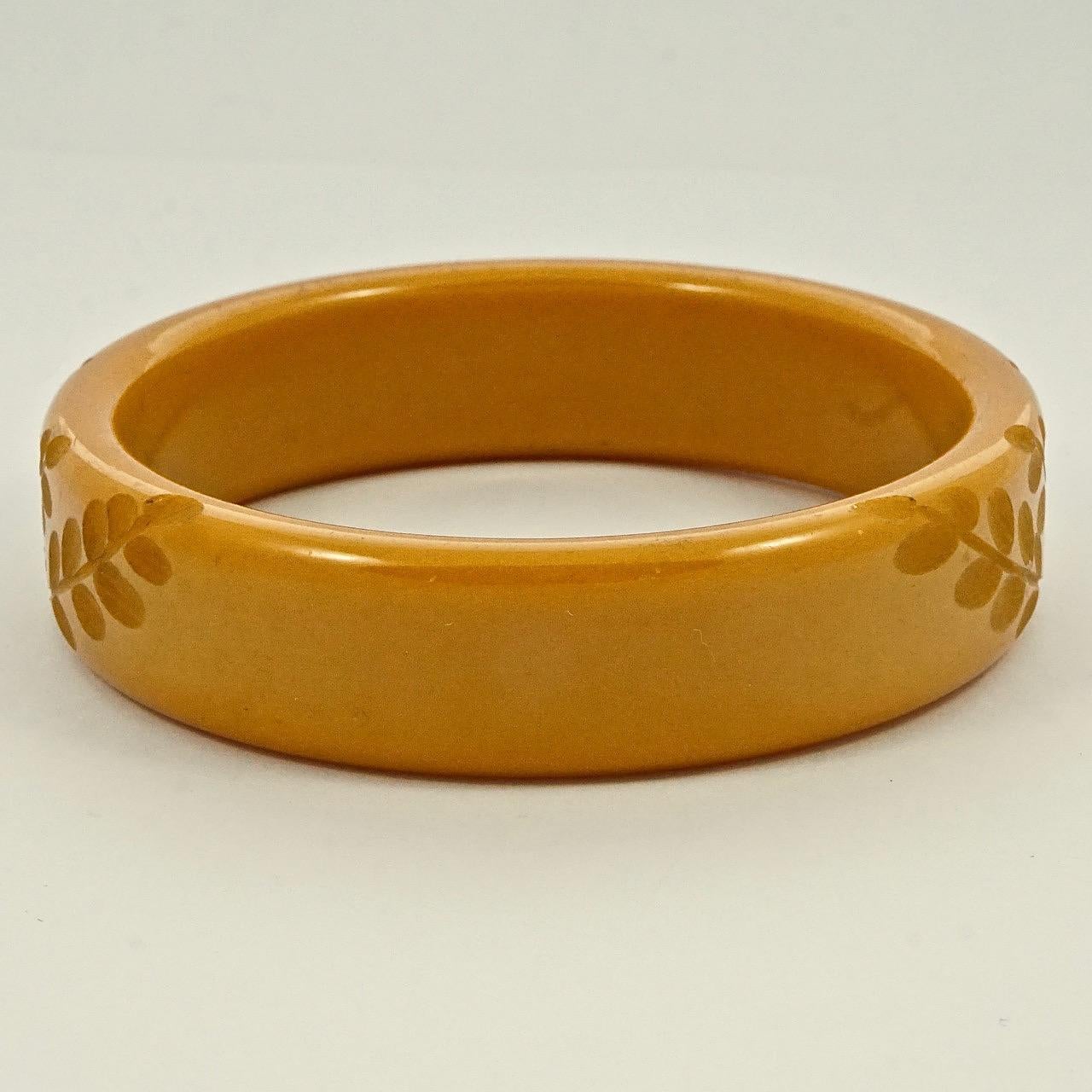 Wonderful Art Deco caramel yellow Bakelite bangle with lovely leaves carving. Inside diameter 6.35cm / 2.5 inches by width 1.7cm / .67 inch. The bangle is in very good condition.

This is a beautiful vintage carved Bakelite bangle in caramel yellow.