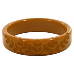 Bracelet jonc Art Déco en bakélite jaune caramel avec feuilles sculptées