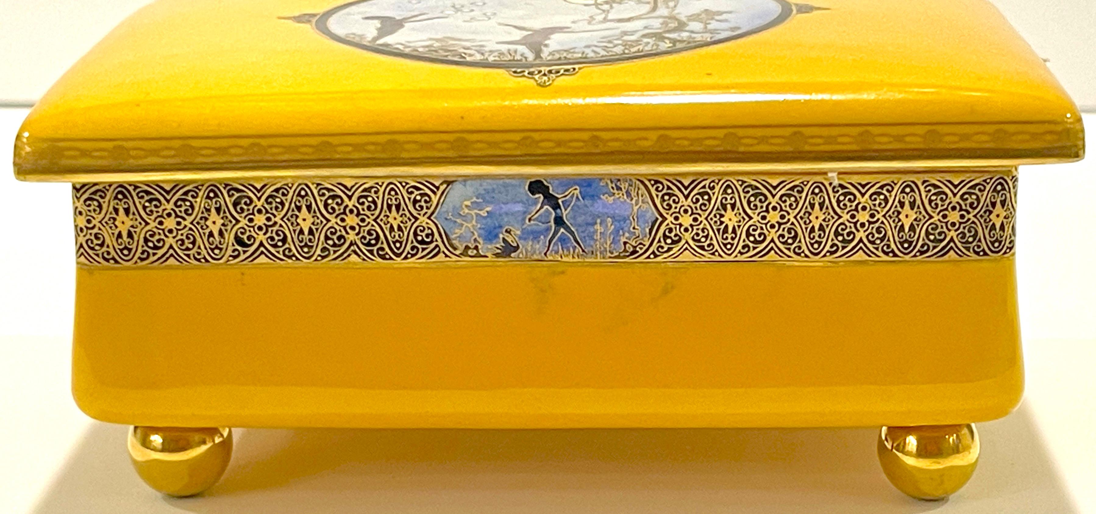 Art Deco carltonware luster moonlight frolicking pixie table box, for Dunhill. 
England, circa 1930s.

An extraordinary example, The rectangular covered box with a canary yellow background with a rare ( Have not found another example of this