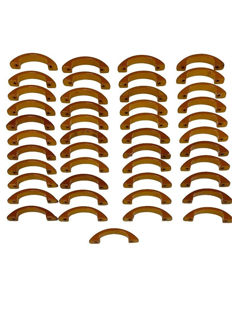 Hard to find a lot of 45 original 1930s caramel/amber color Catalin (Colored Bakelite) drawer pulls. It is ideal for restoration and housing projects keeping to their original design and period. Elevate your decor with a piece of history and