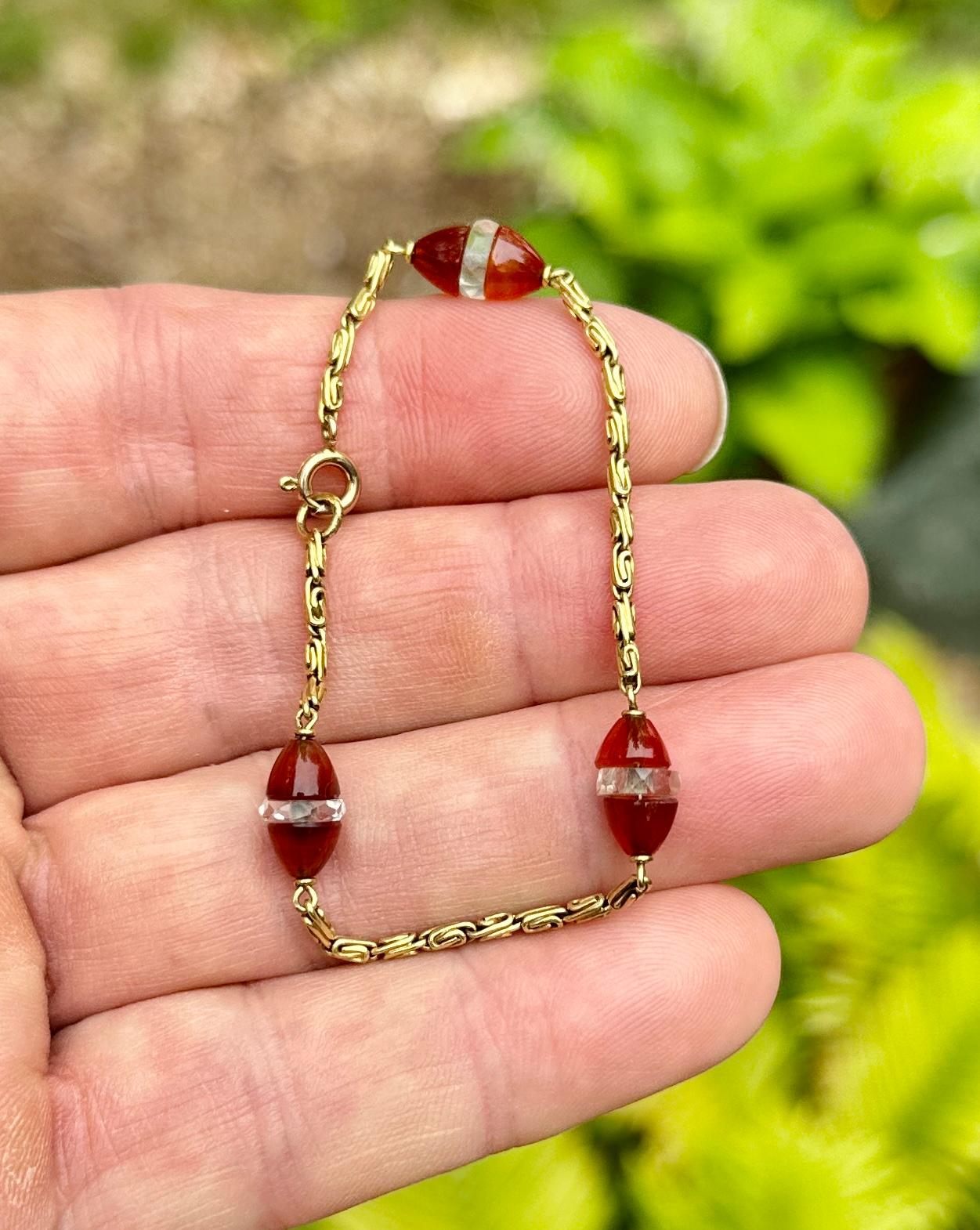 Indulge in a radiant Art Deco Carnelian and Rock Crystal 18 Karat Gold Bracelet. The exquisite antique Art Deco link bracelet is set with three Carnelian and Rock Crystal Rondelles. The rondelles have torpedo shaped ends of fine Carnelian gems with