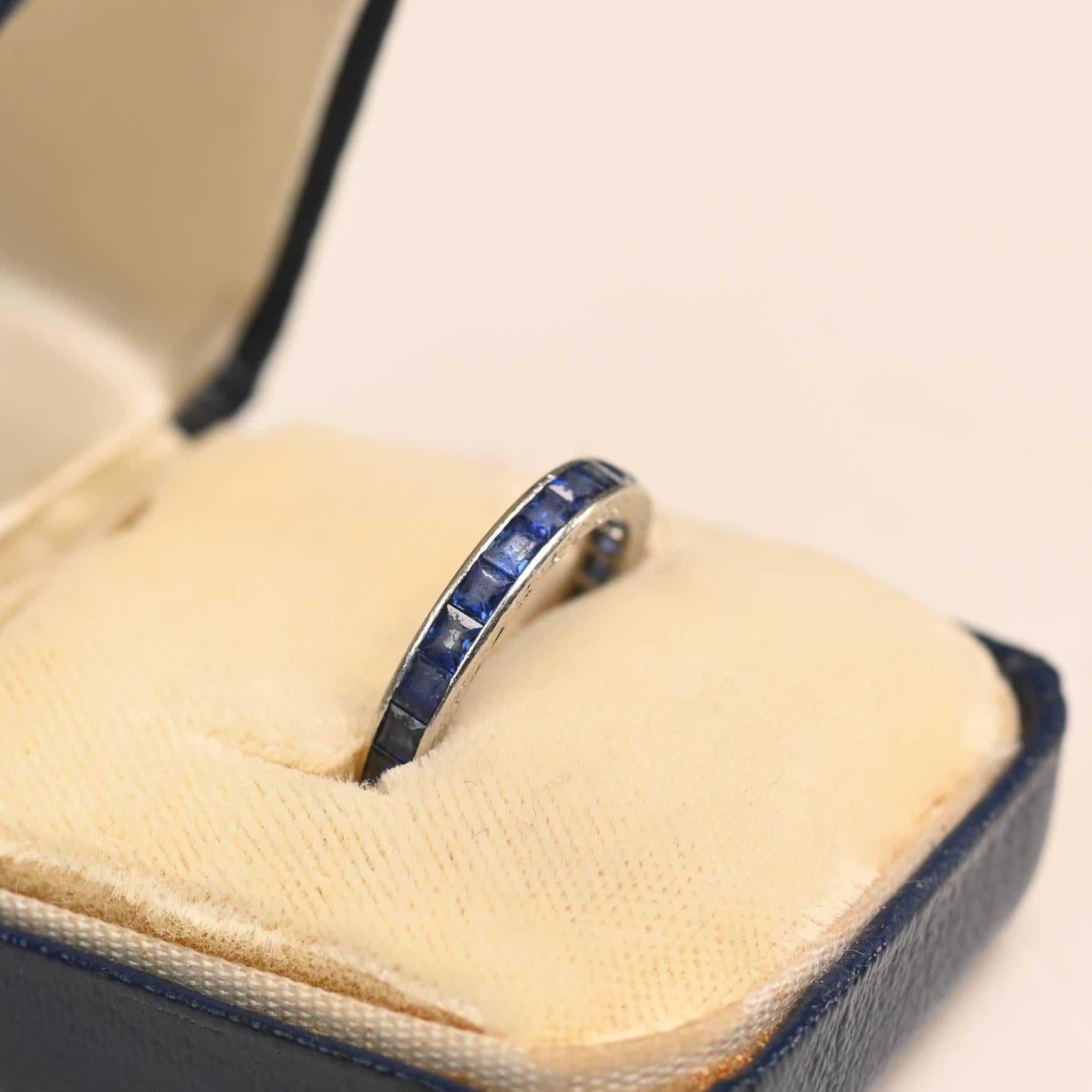 Un'elegante fascia per l'eternità di epoca Art Deco che mostra una fila continua di pietre di zaffiro taglio carrè, splendidamente incastonate in una precisa montatura a canale. Gli zaffiri presentano una ricca tonalità di blu intenso, aggiungendo