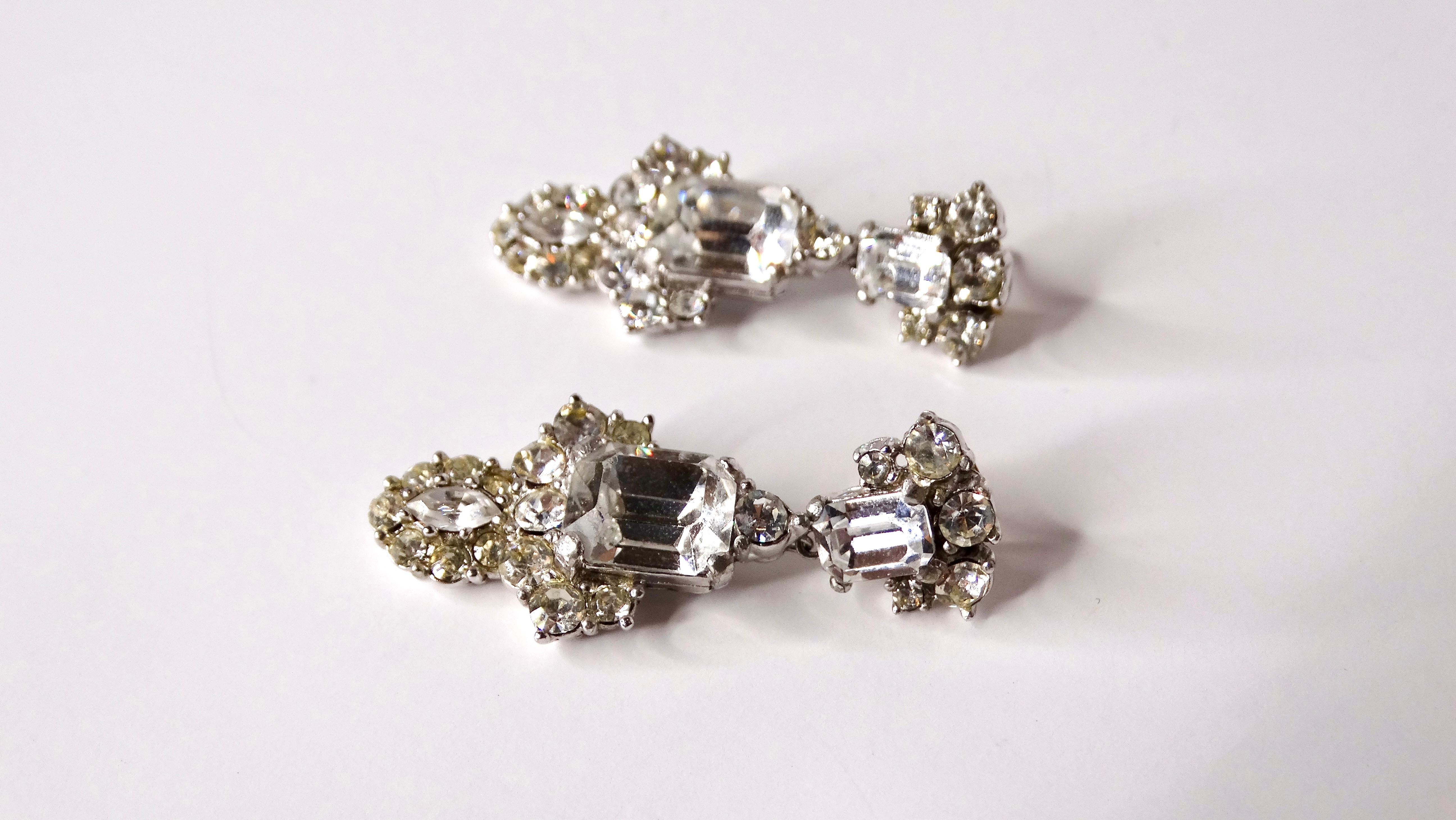 Entra in un mondo di eleganza con questi splendidi orecchini a pendente in argento placcato con strass ispirati all'Art Deco di Cartier. Realizzati con un'attenzione meticolosa ai dettagli, questi orecchini sono un tributo all'estetica del design di