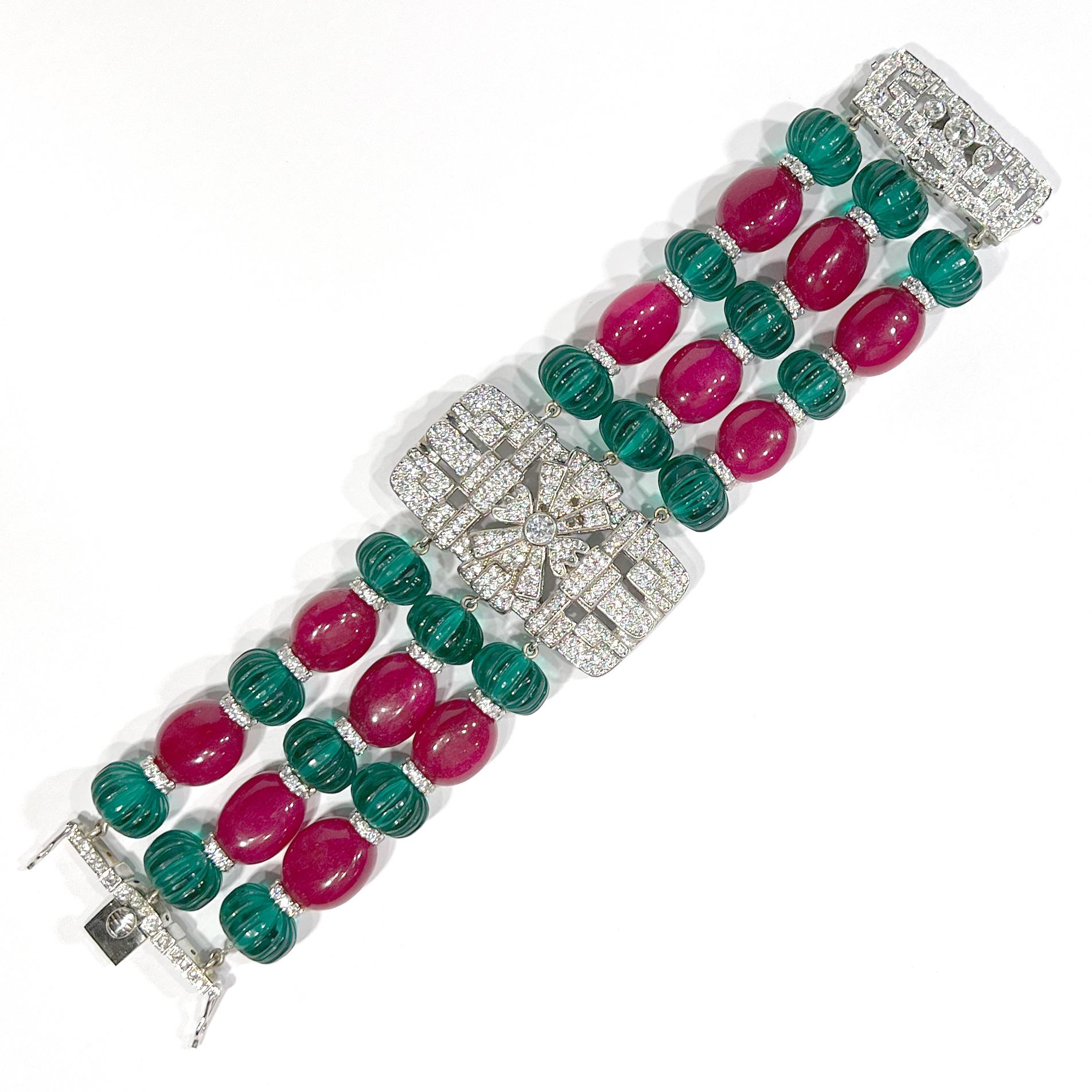 
Art Deco Cartier Style emerald carved beads, cabochon rubies, diamond costume jewelry bracelet mounted in rhodiumed sterling silver. Man made gems of the finest quality. Stunning large pave Art Deco centre for an extra rich effect and a handmade