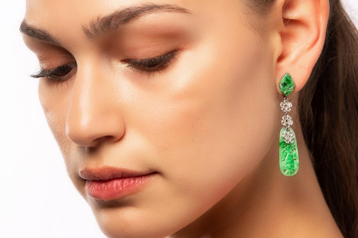 An elegant and classic pair of Art Deco Chinese carved jade and diamond drop earrings mounted in platinum with 14k gold screw backs. 

The jade of fairly even green hue. The lower sections carved and pierced with a flower vase design. The upper