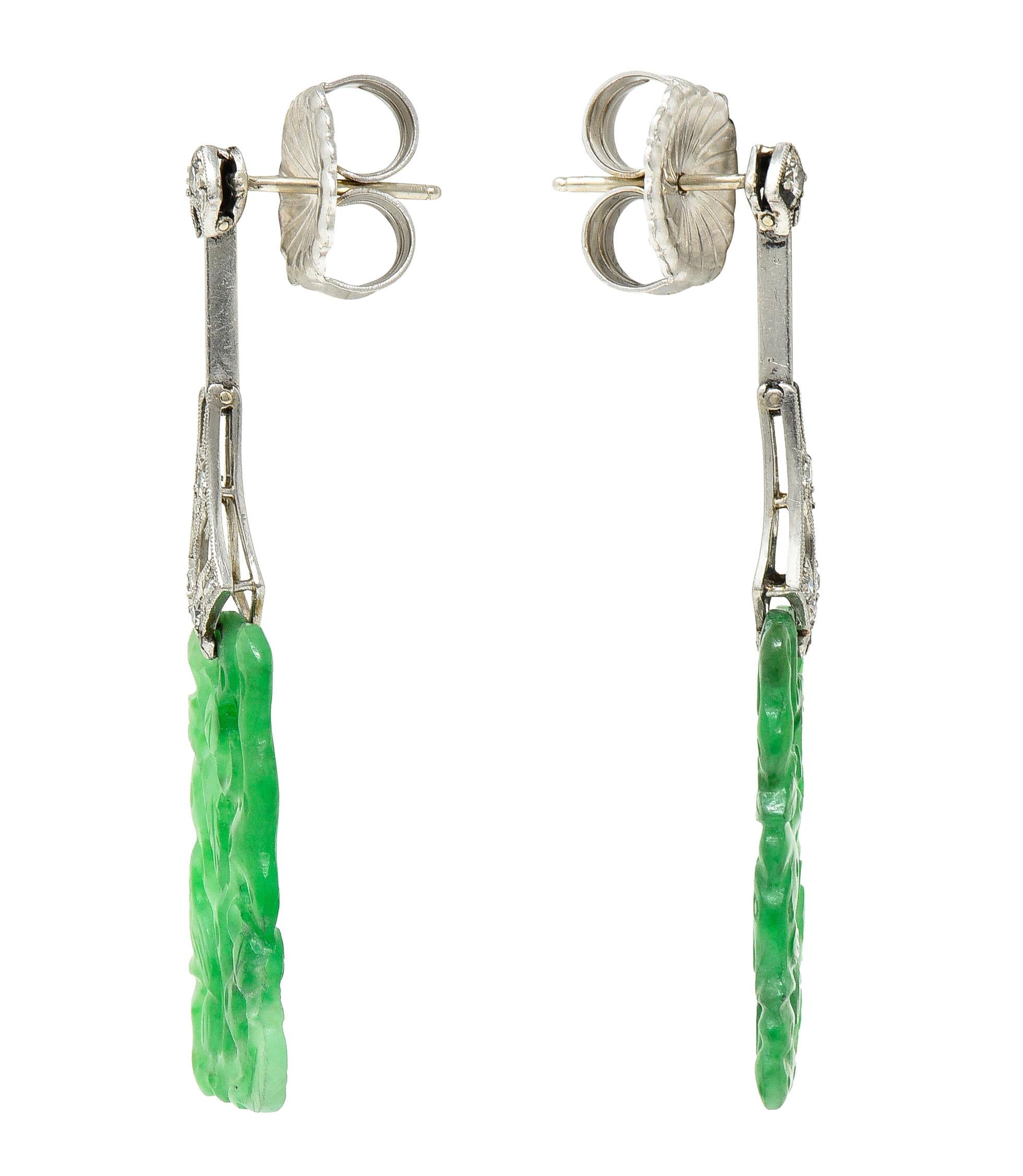 Featuring tapered rectangular shaped carved jade drops depicting foliage and birds. Measuring 9.5 x 21.0 mm - translucent light bluish-green to medium green in color. Suspending from pierced platinum surmounts - hinged to articulate. Featuring
