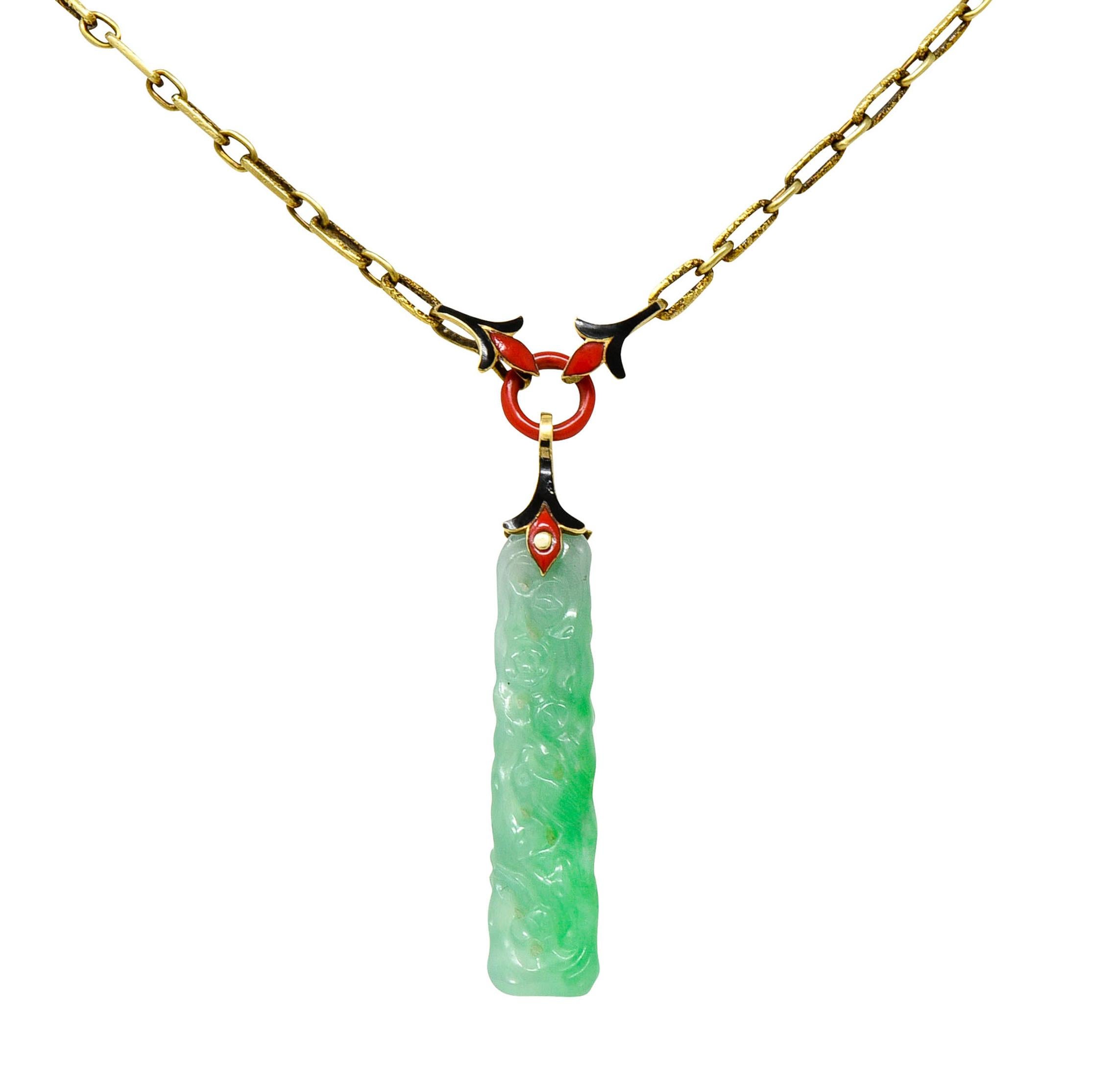 Necklace is comprised of elongated links alternating in texture

With a stylized floral central station glossed with black and red enamel - exhibiting some loss

Suspending a long tabular piece of jade - translucent light green to saturated